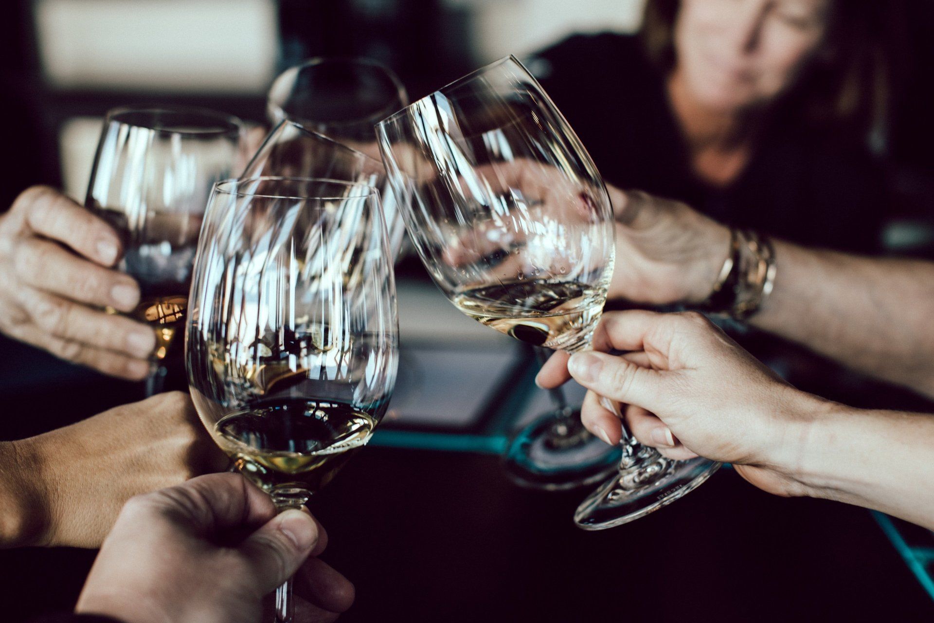 Un gruppo di persone sta brindando con calici di vino seduti a un tavolo.