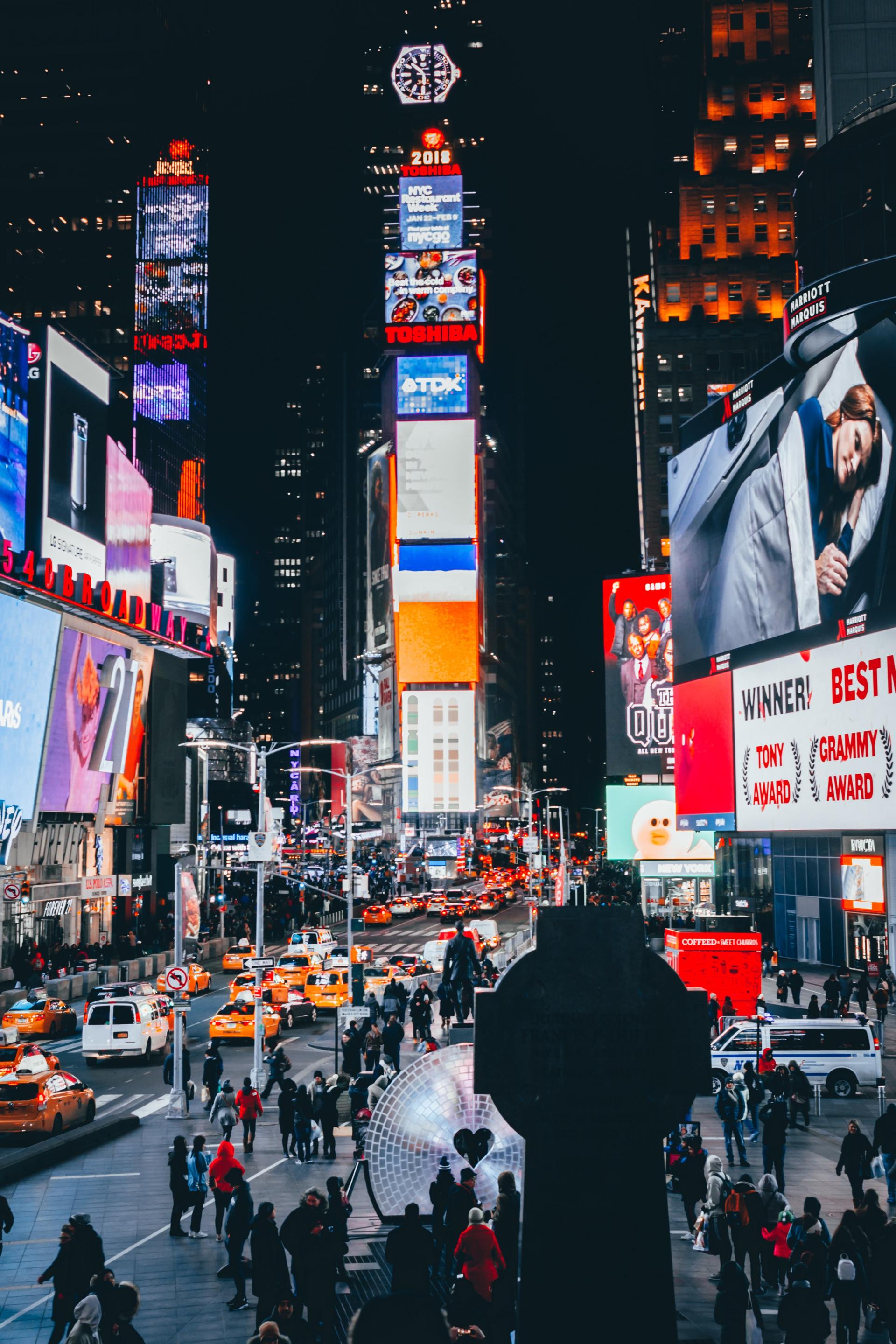A busy city street at night with a stop sign in the foreground