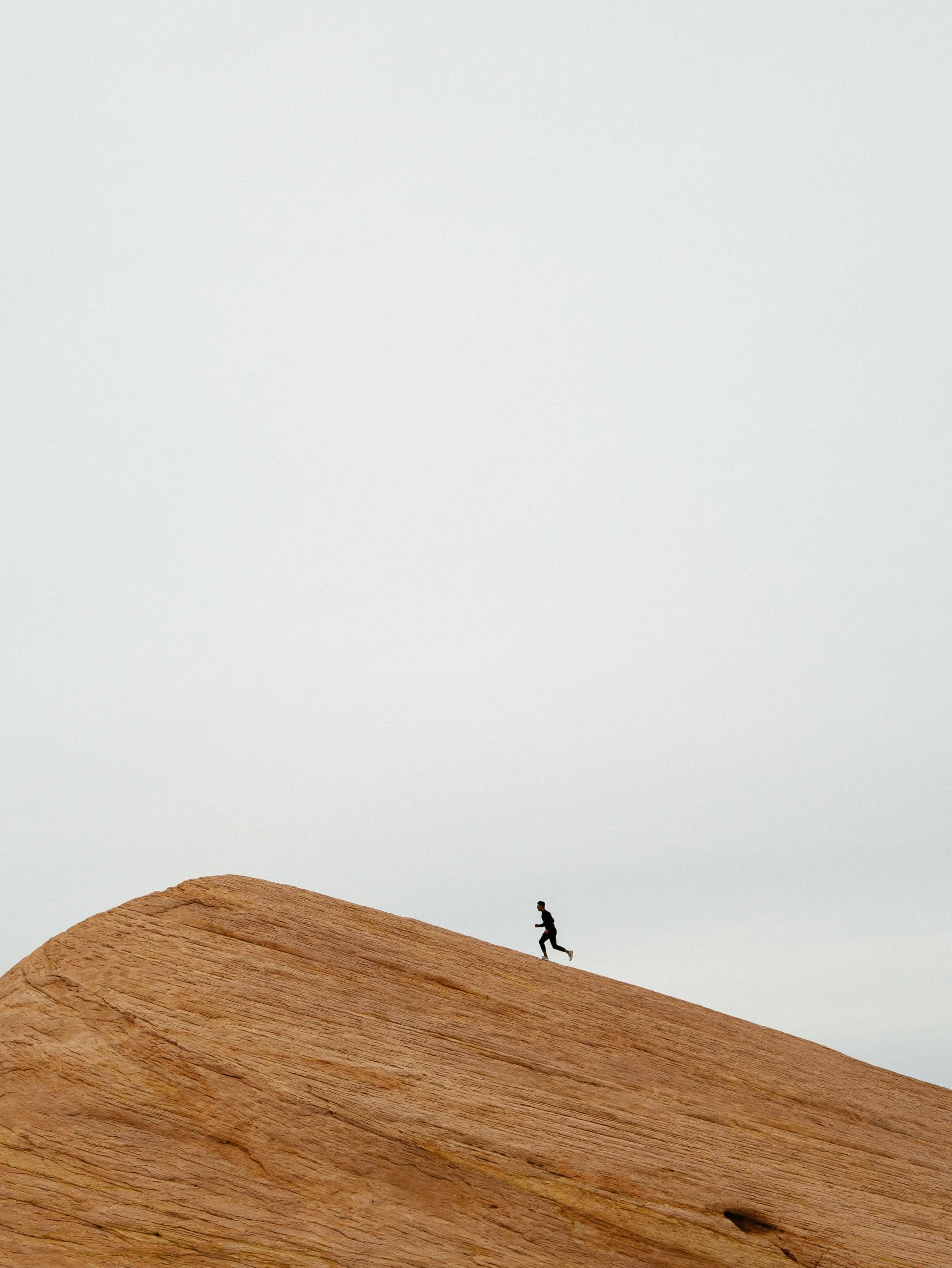 A person is standing on top of a wooden hill.
