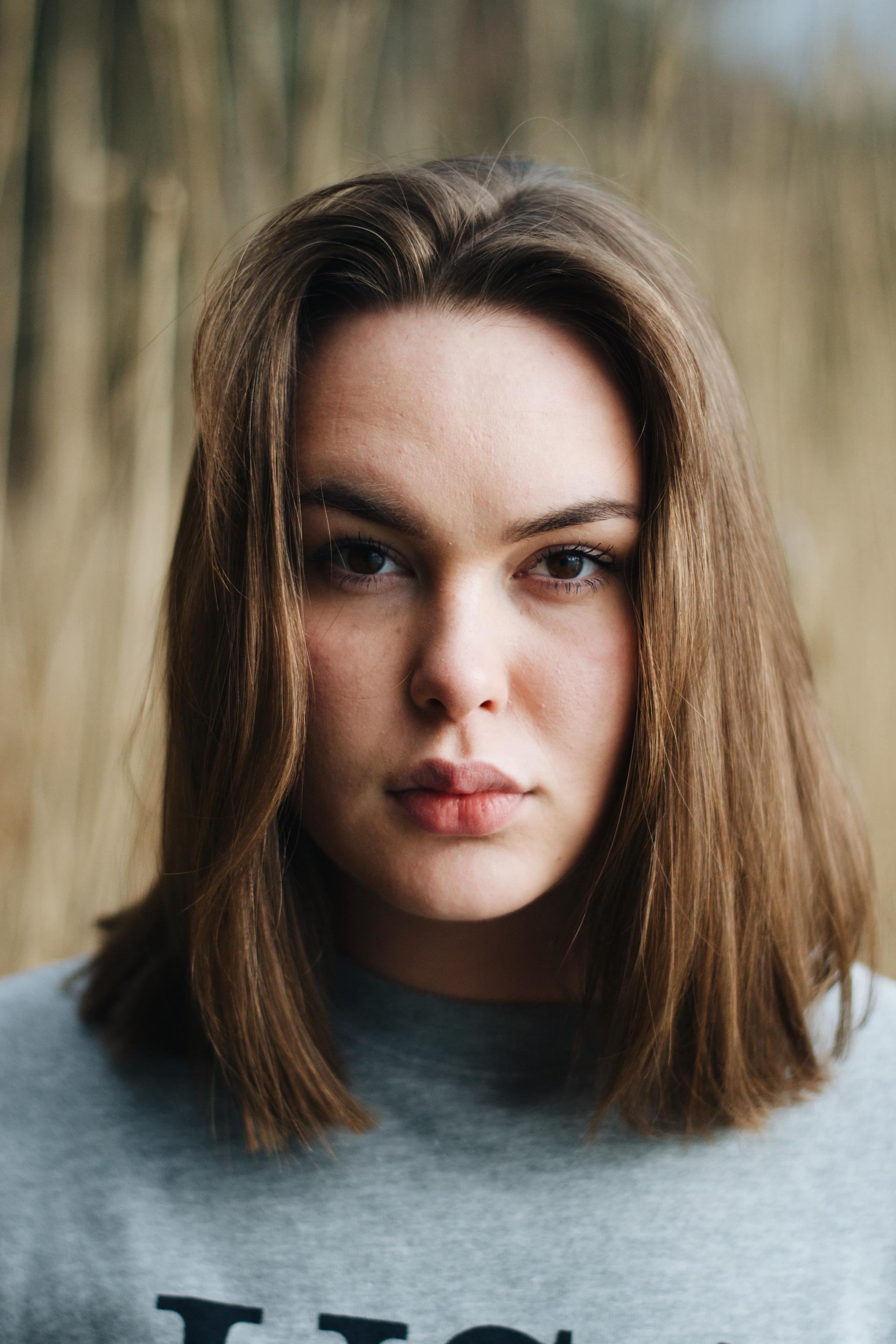 A close up of a woman 's face wearing a gray shirt.