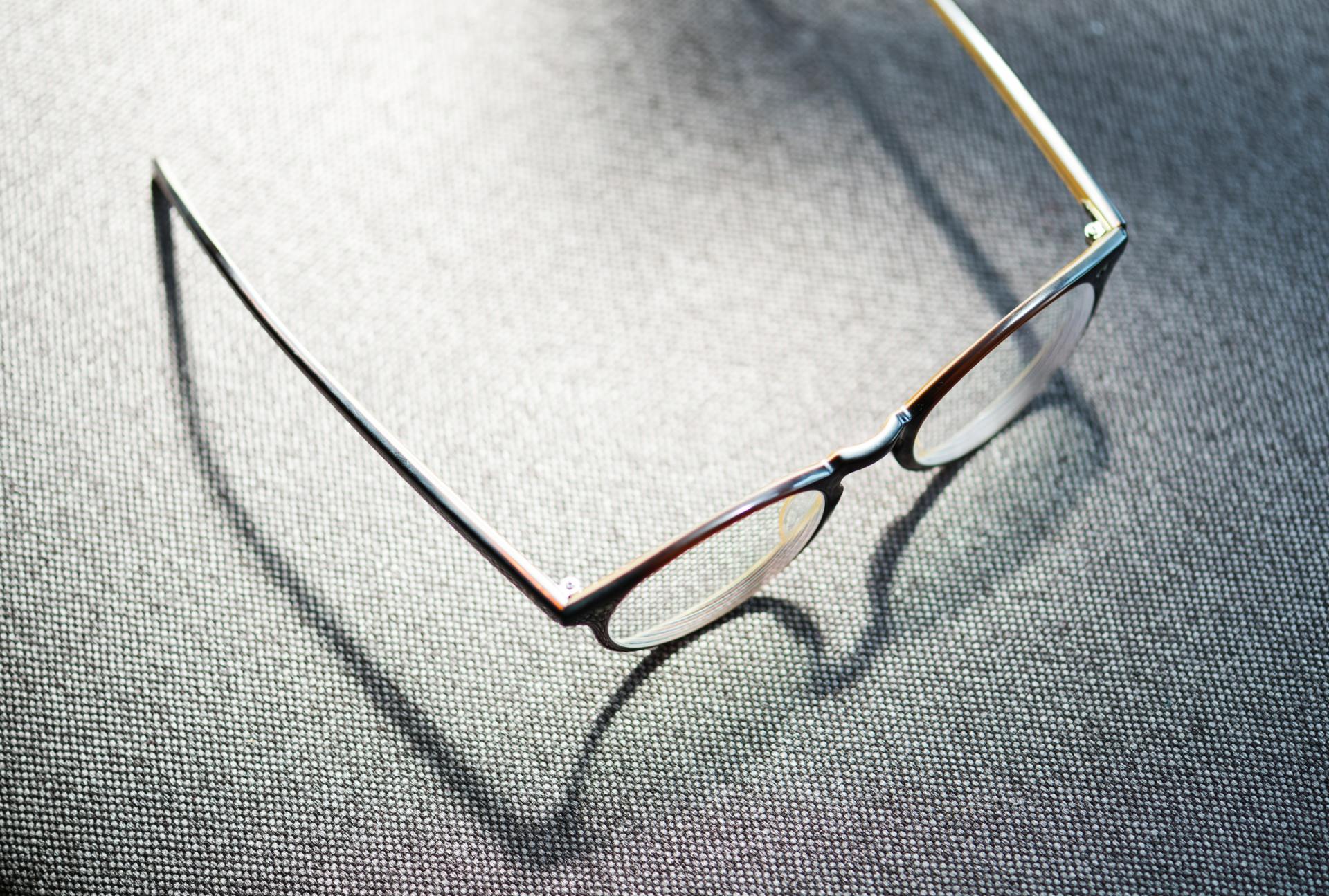 a pair of glasses is laying on a gray surface .