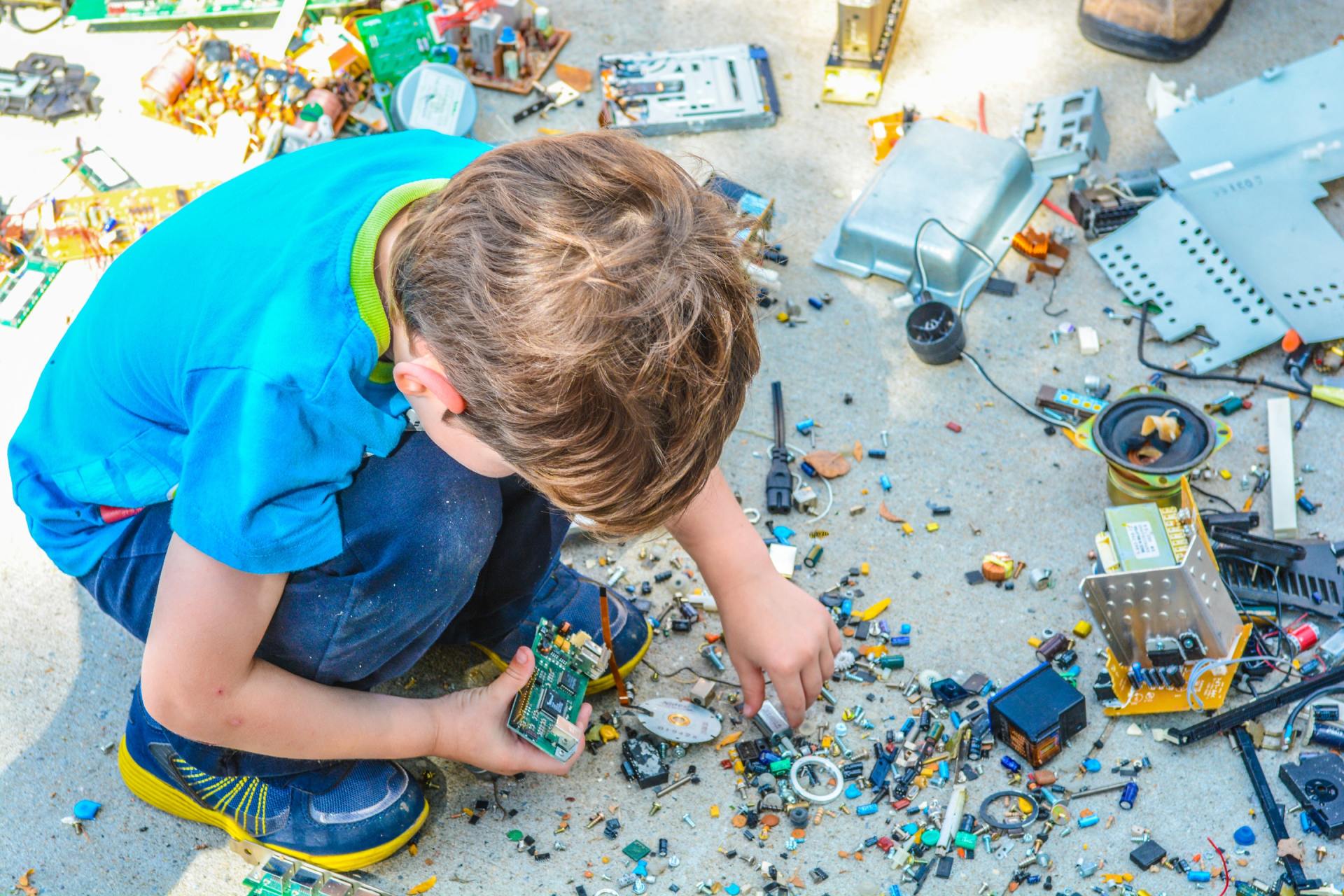 A young boy is playing with a pile of lego bricks on the ground.