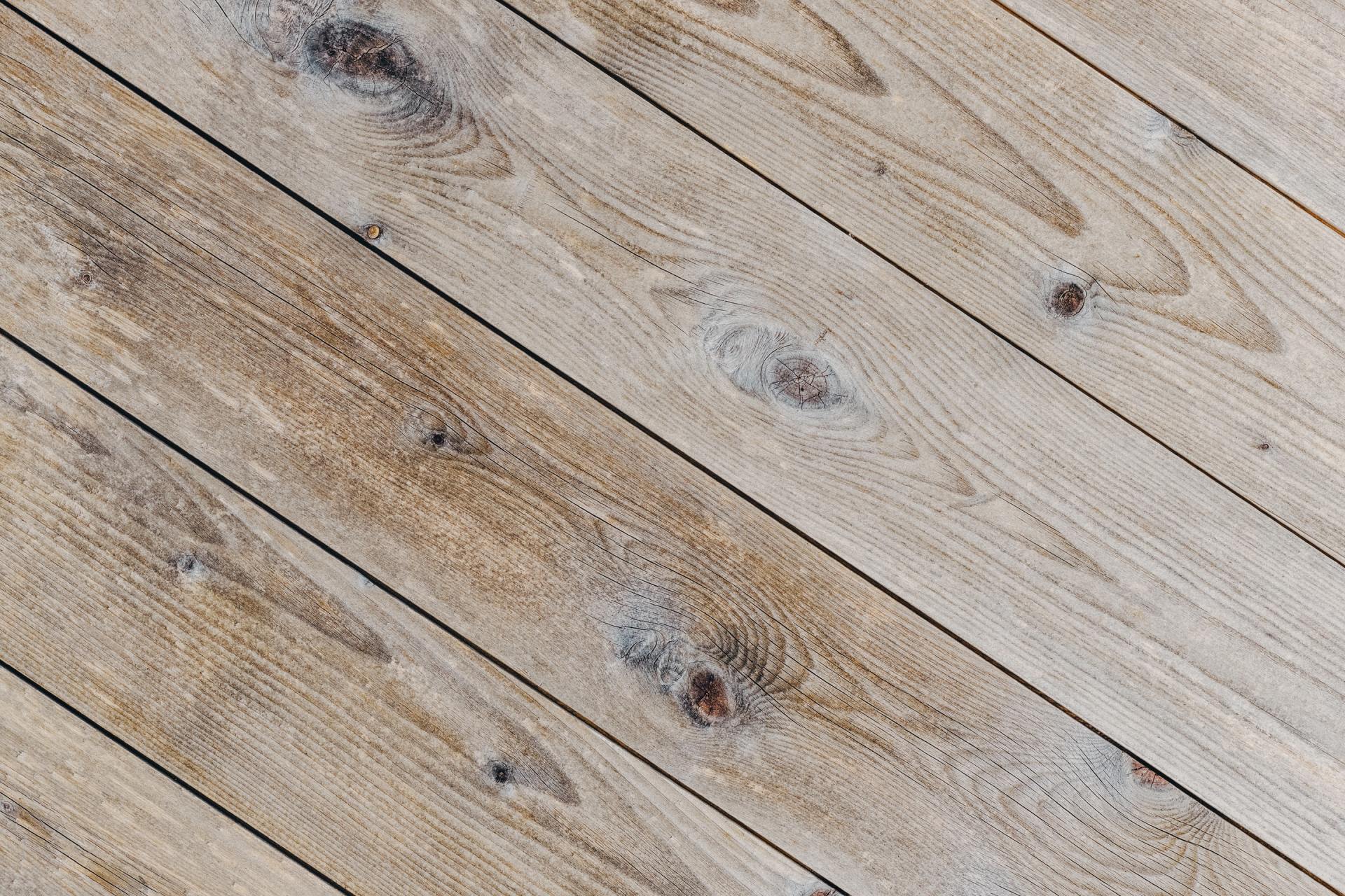 A close up of a wooden floor with a diagonal pattern.