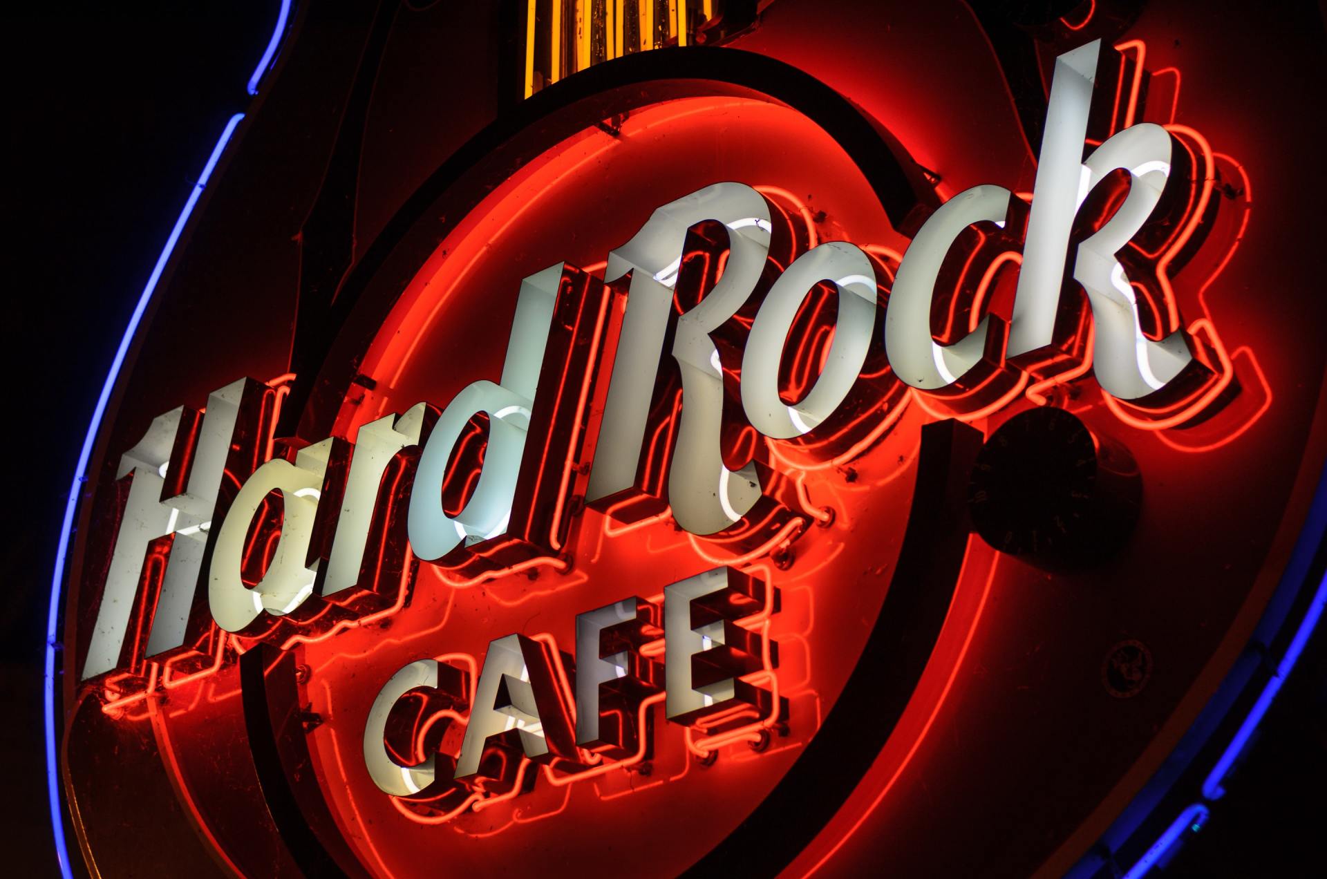 A neon sign for hard rock cafe is lit up at night