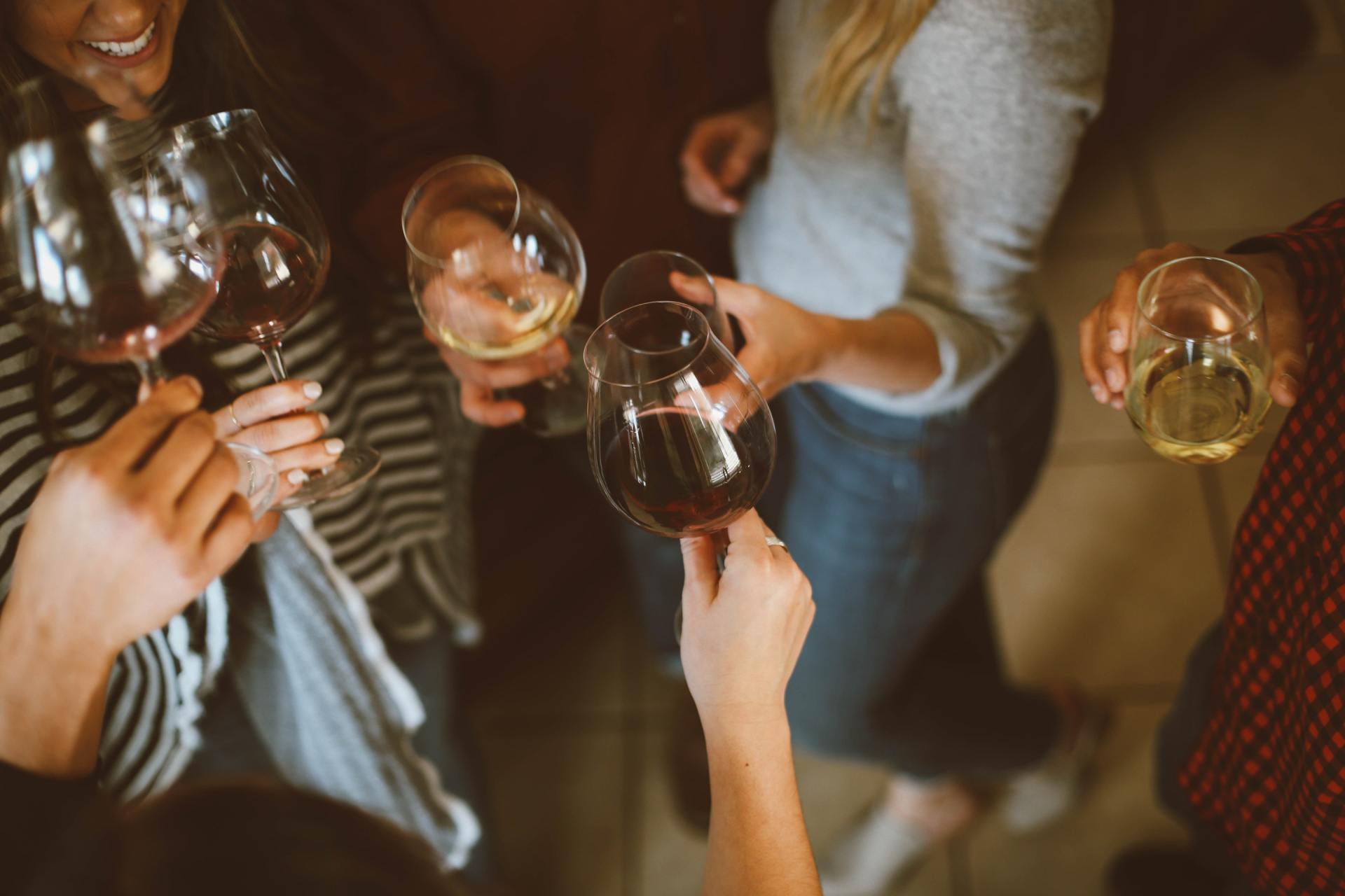 Un gruppo di persone brinda con bicchieri di vino a una festa.