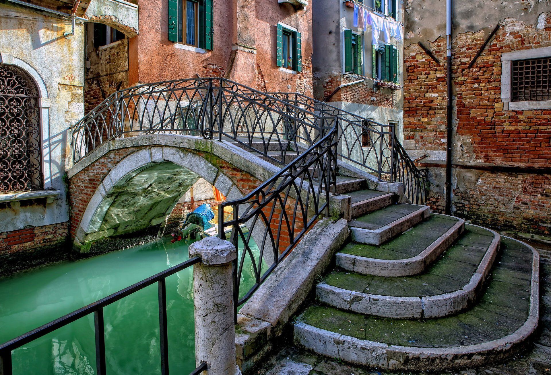 A bridge over a canal with stairs leading to it.