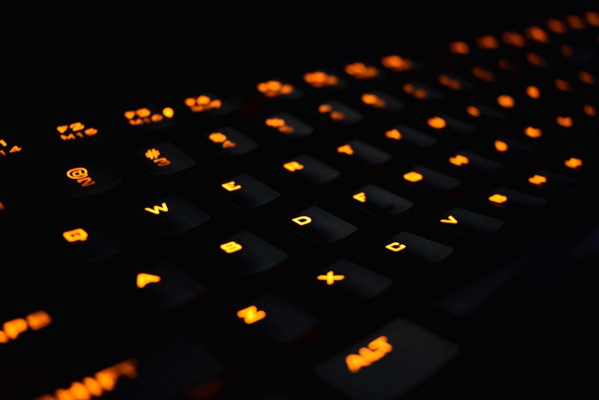 A close up of a black keyboard with orange keys