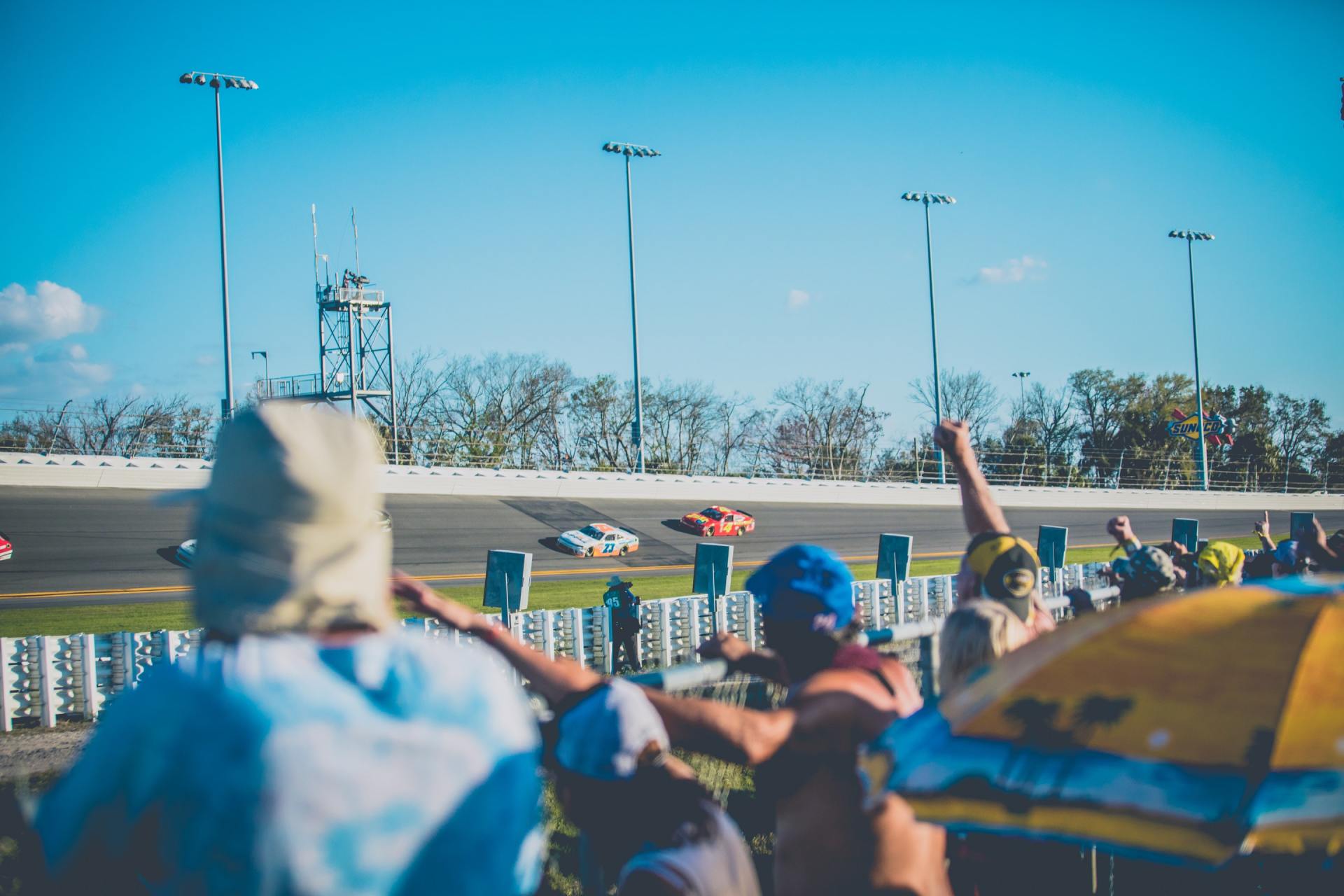A crowd of people are watching a race on a race track.