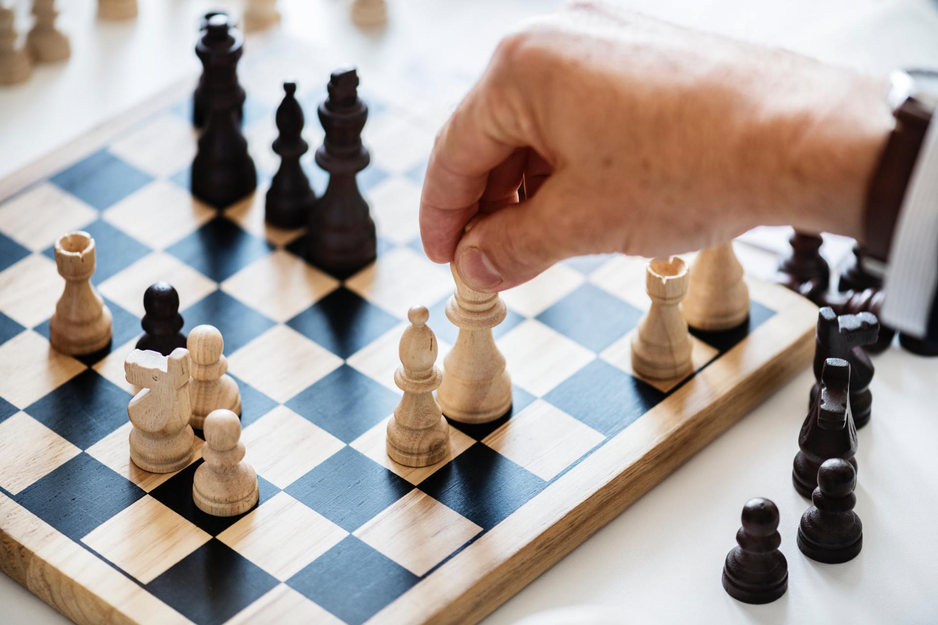 A person is playing a game of chess on a wooden board.
