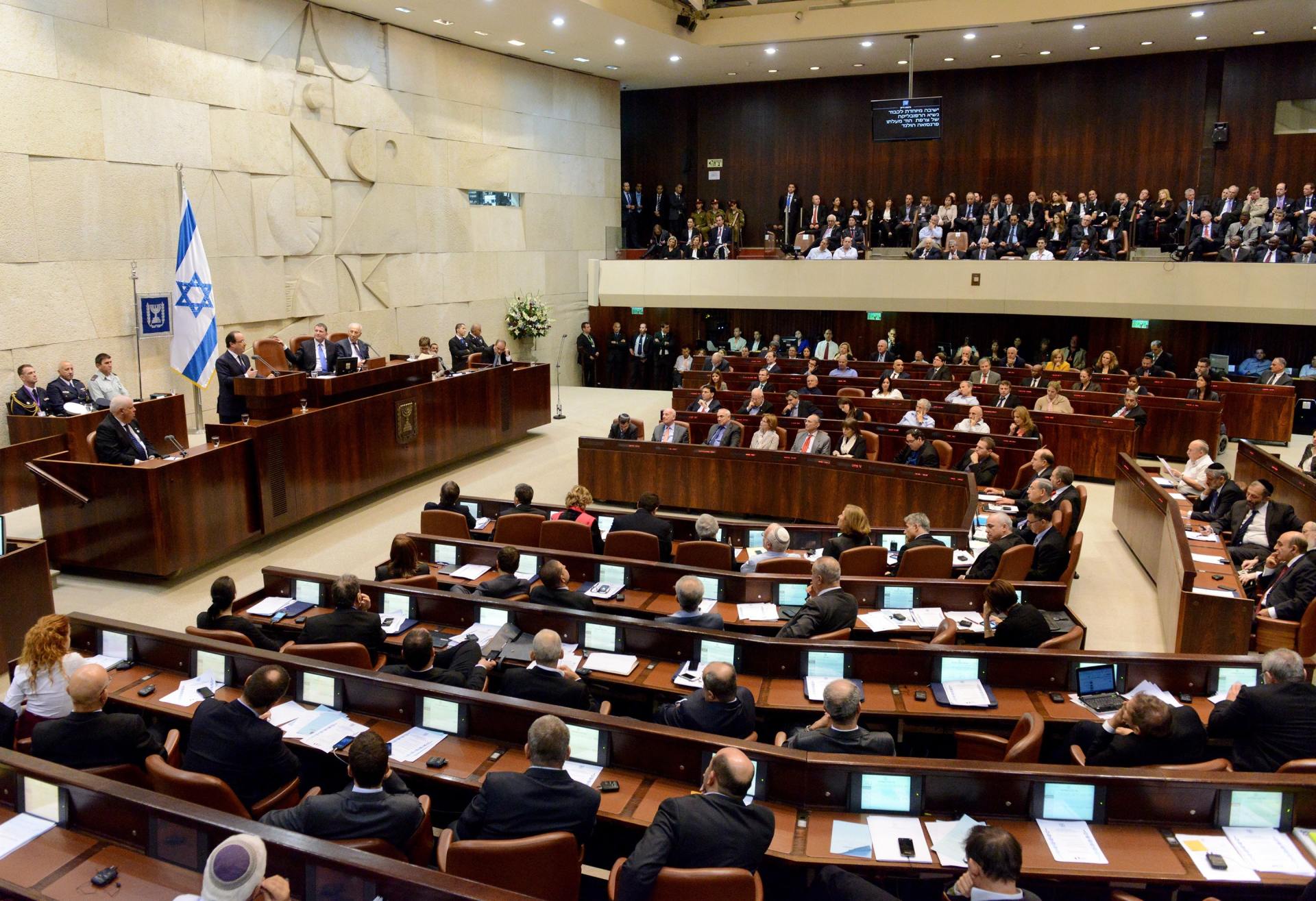 A large group of people are sitting in a parliament building