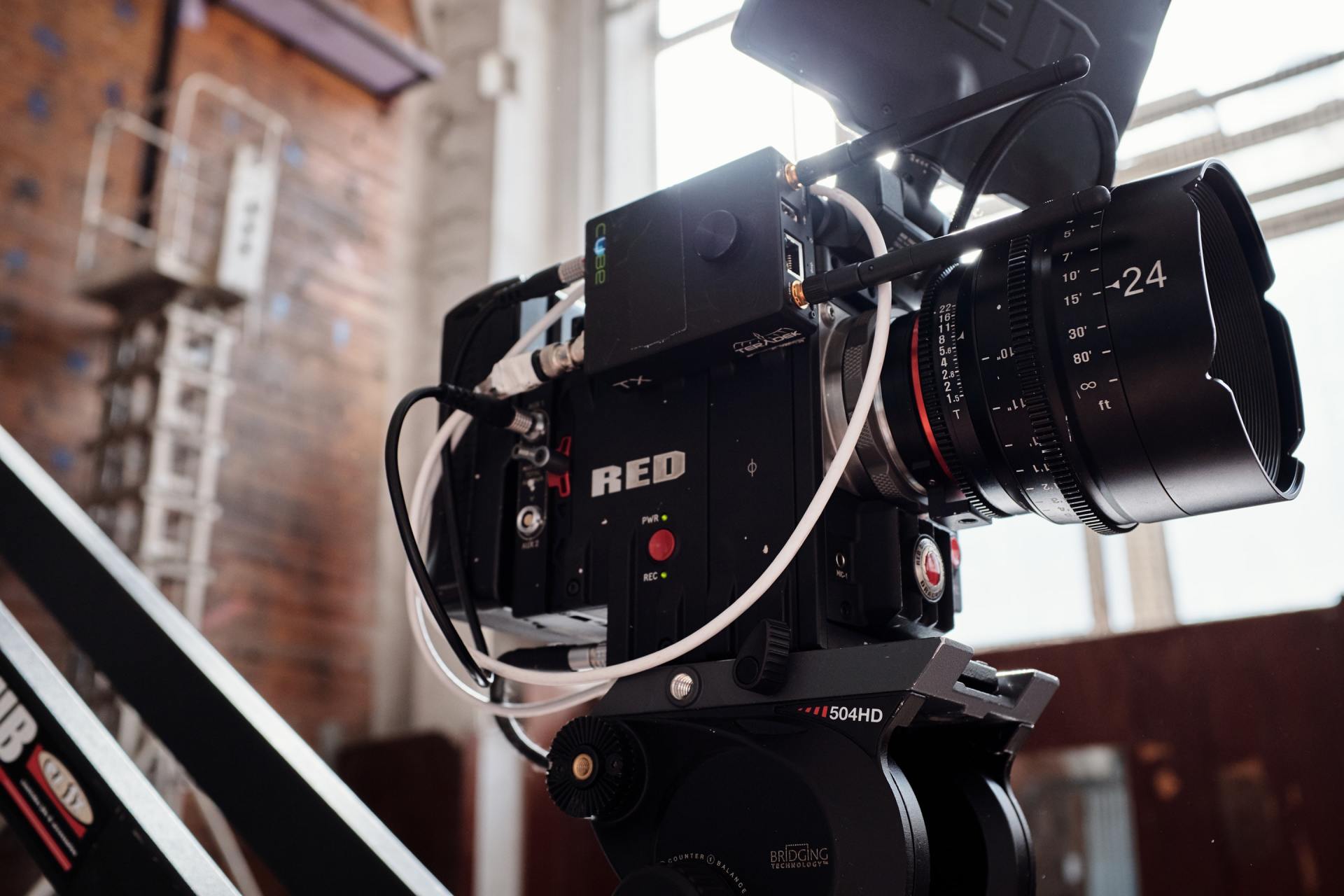 A red camera is sitting on top of a table in a room.