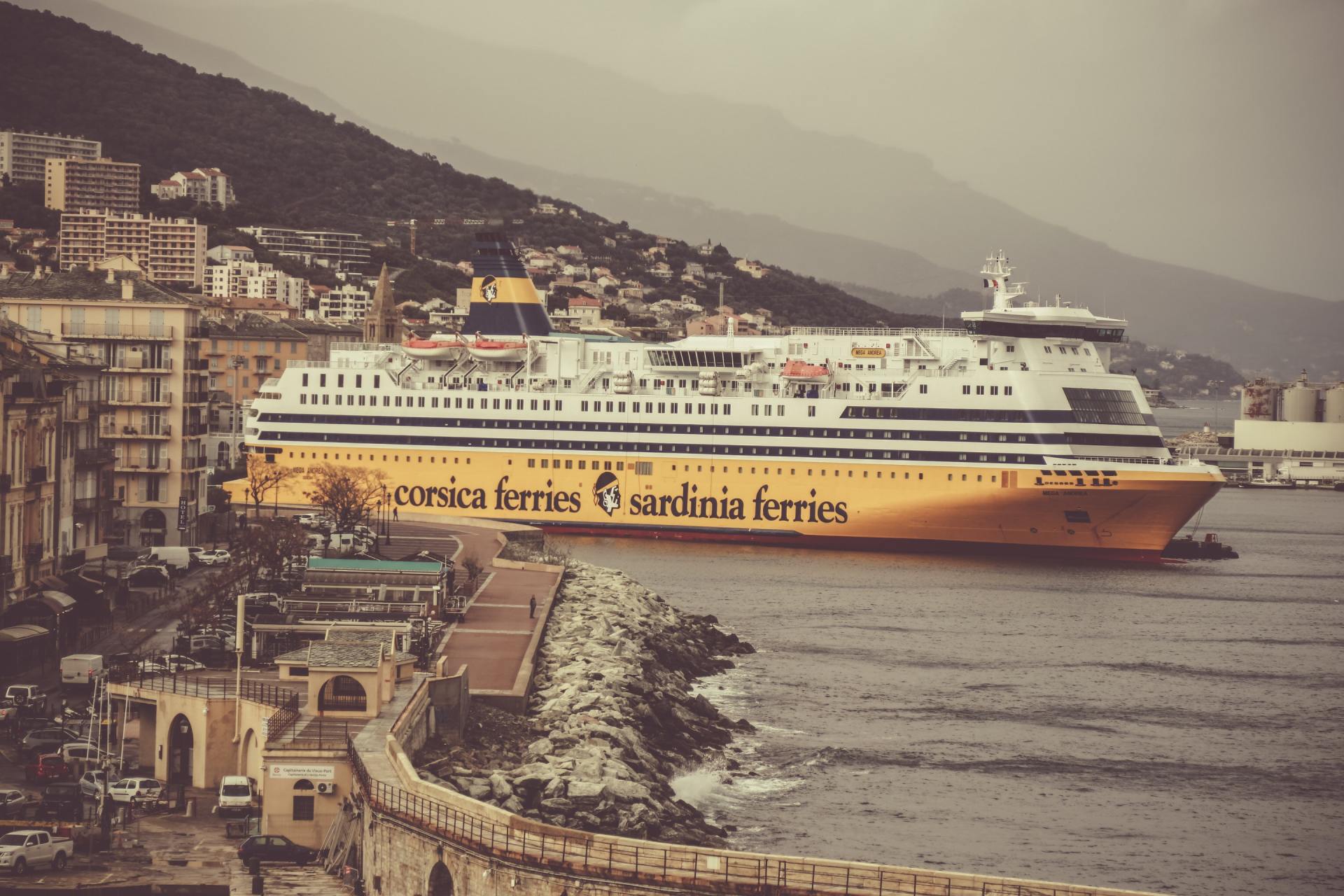 Ein großes Schiff liegt in einem Hafen angedockt und sagt Corsica Ferries