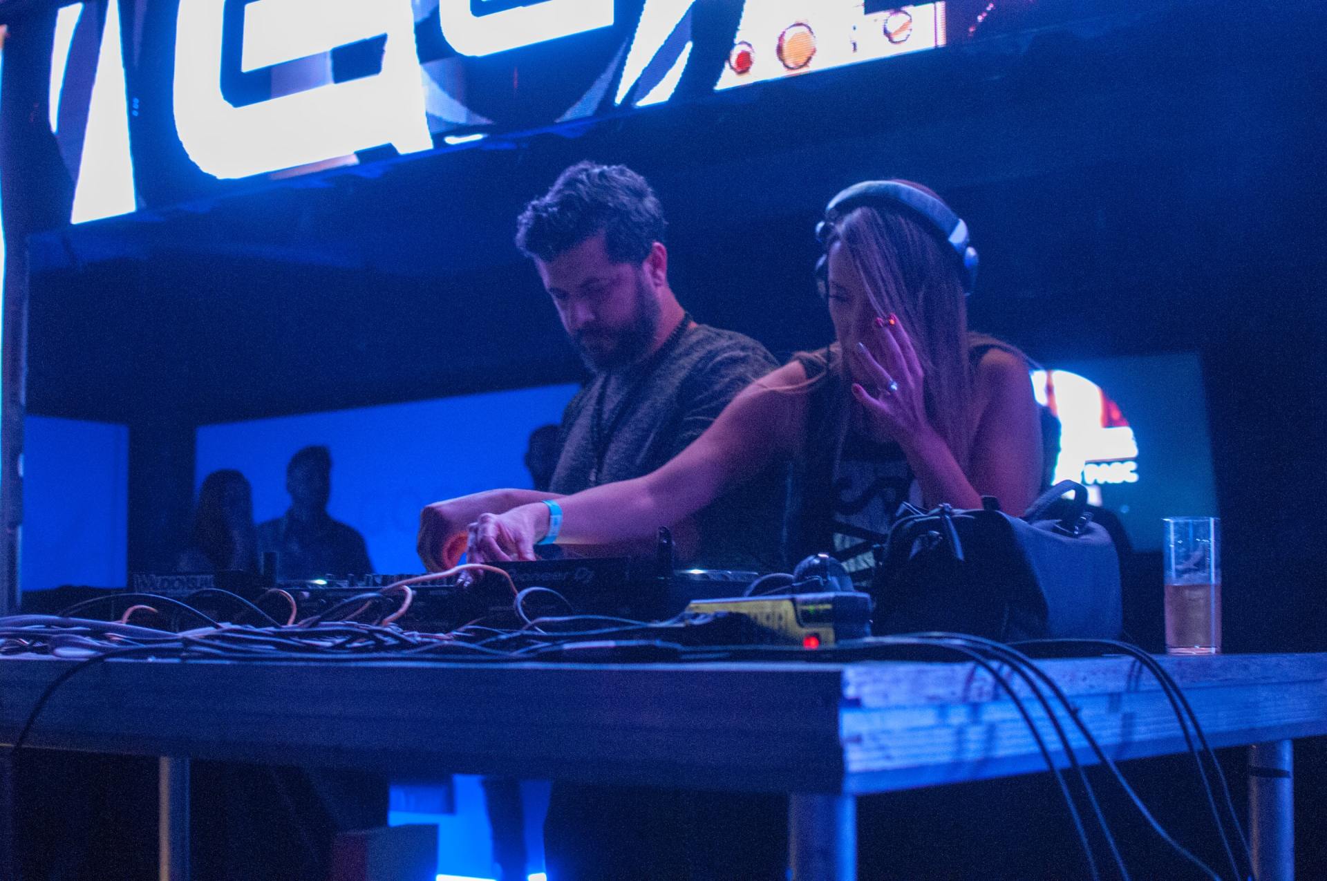 A man and a woman are playing music on a stage in front of a sign that says ' coca cola '