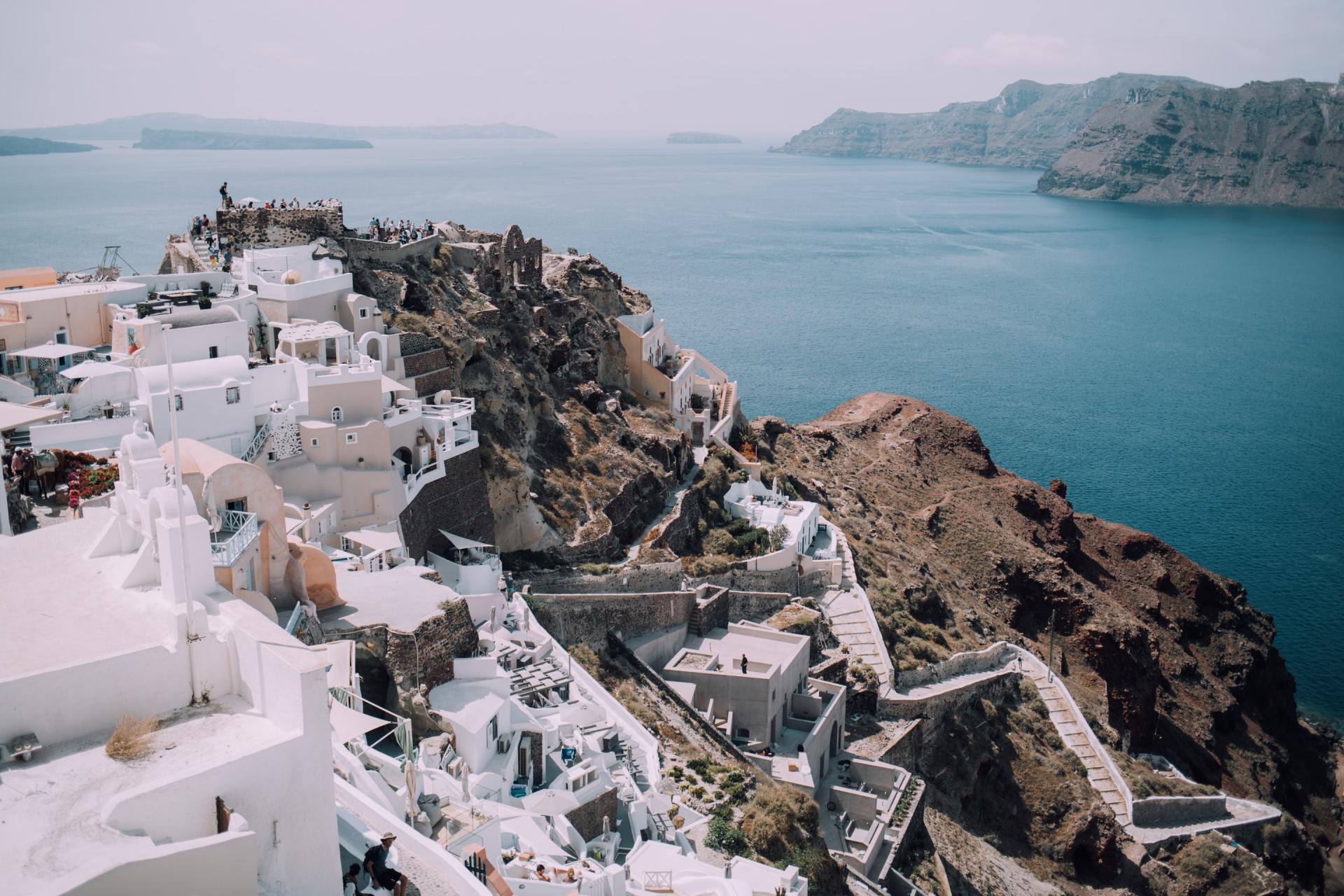 An aerial view of a small town on a cliff overlooking the ocean.