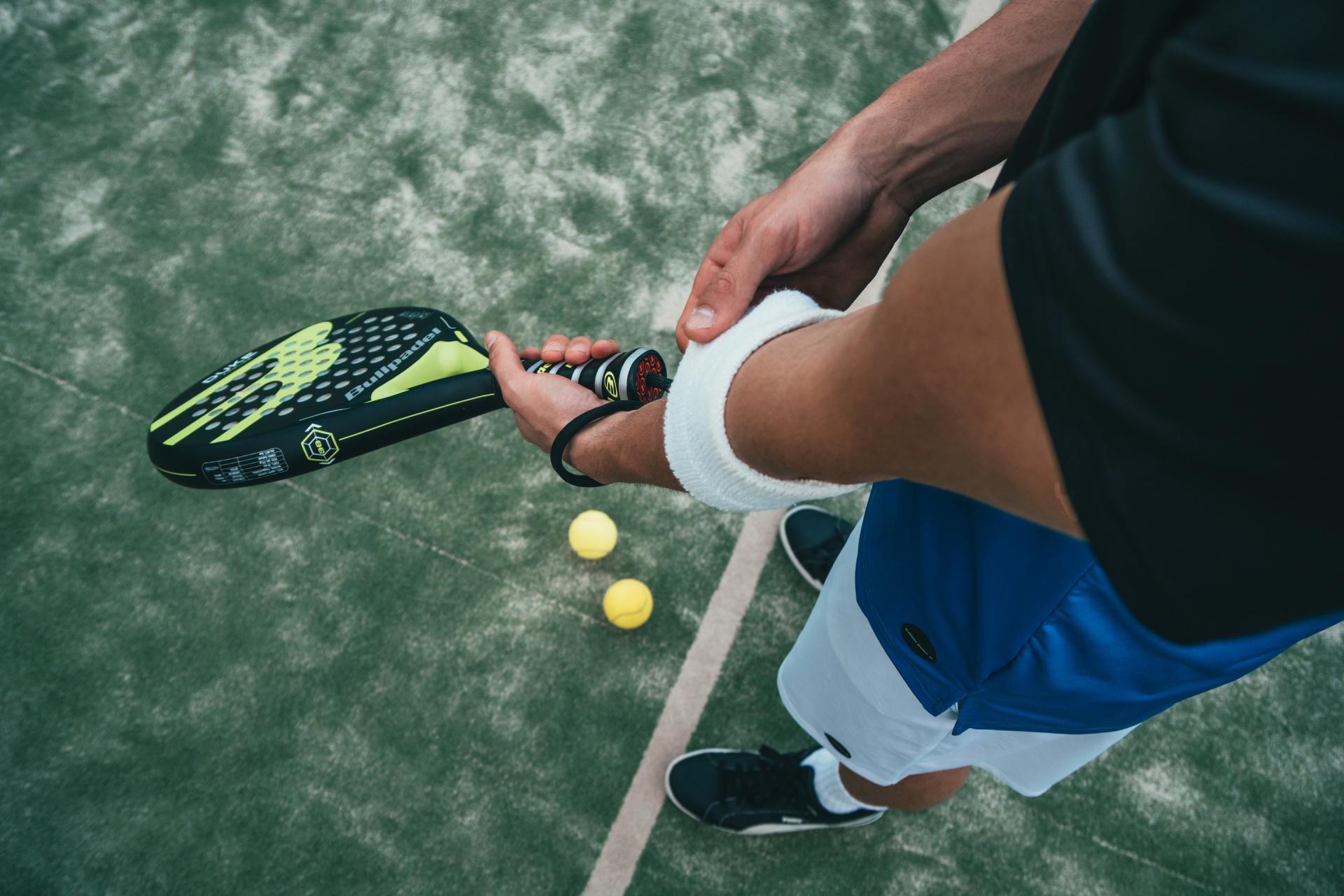 A person is holding a tennis racket on a tennis court.