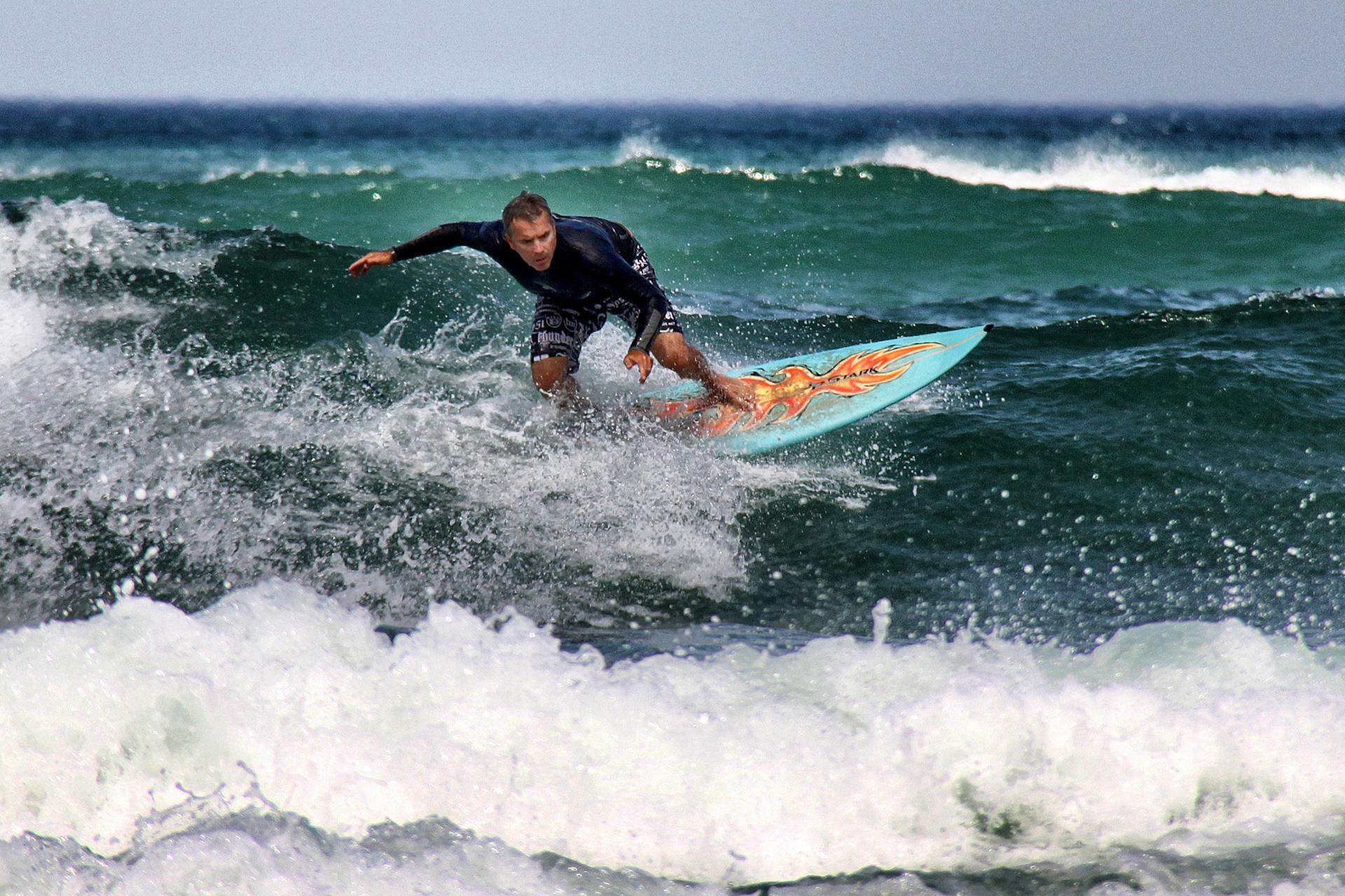 A man is riding a wave on a surfboard in the ocean