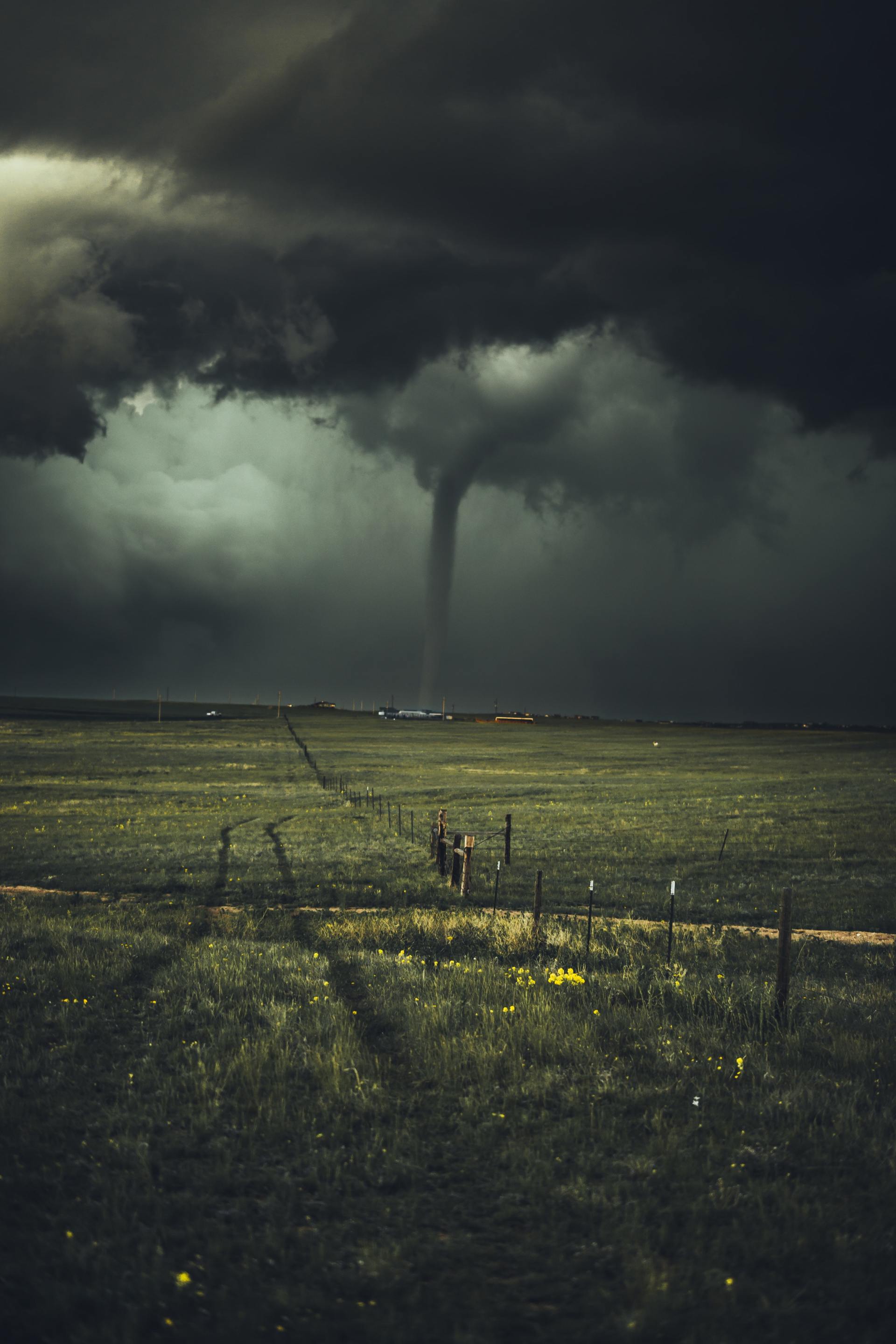 A tornado is coming through a field at night.