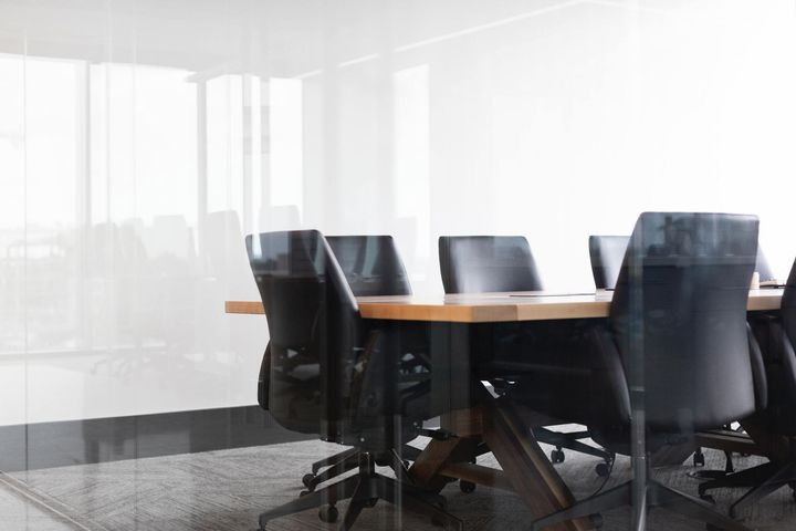 A conference room with a table and chairs and a large window