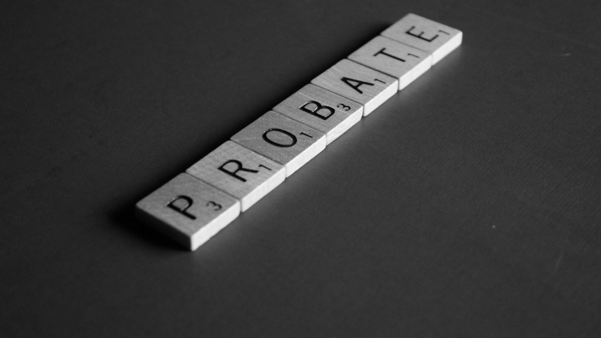 the word probate is written in scrabble tiles on a black surface .