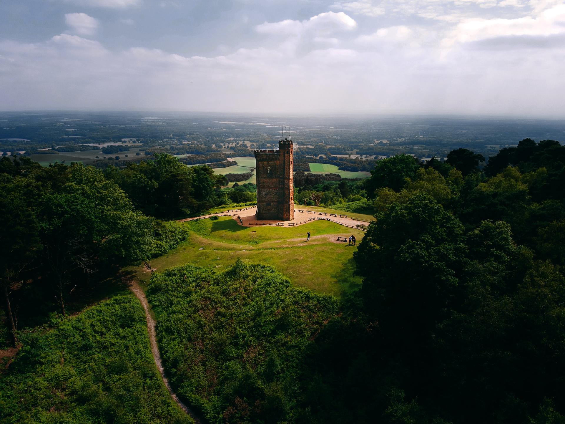 An aerial view of a castle on top of a hill surrounded by trees.