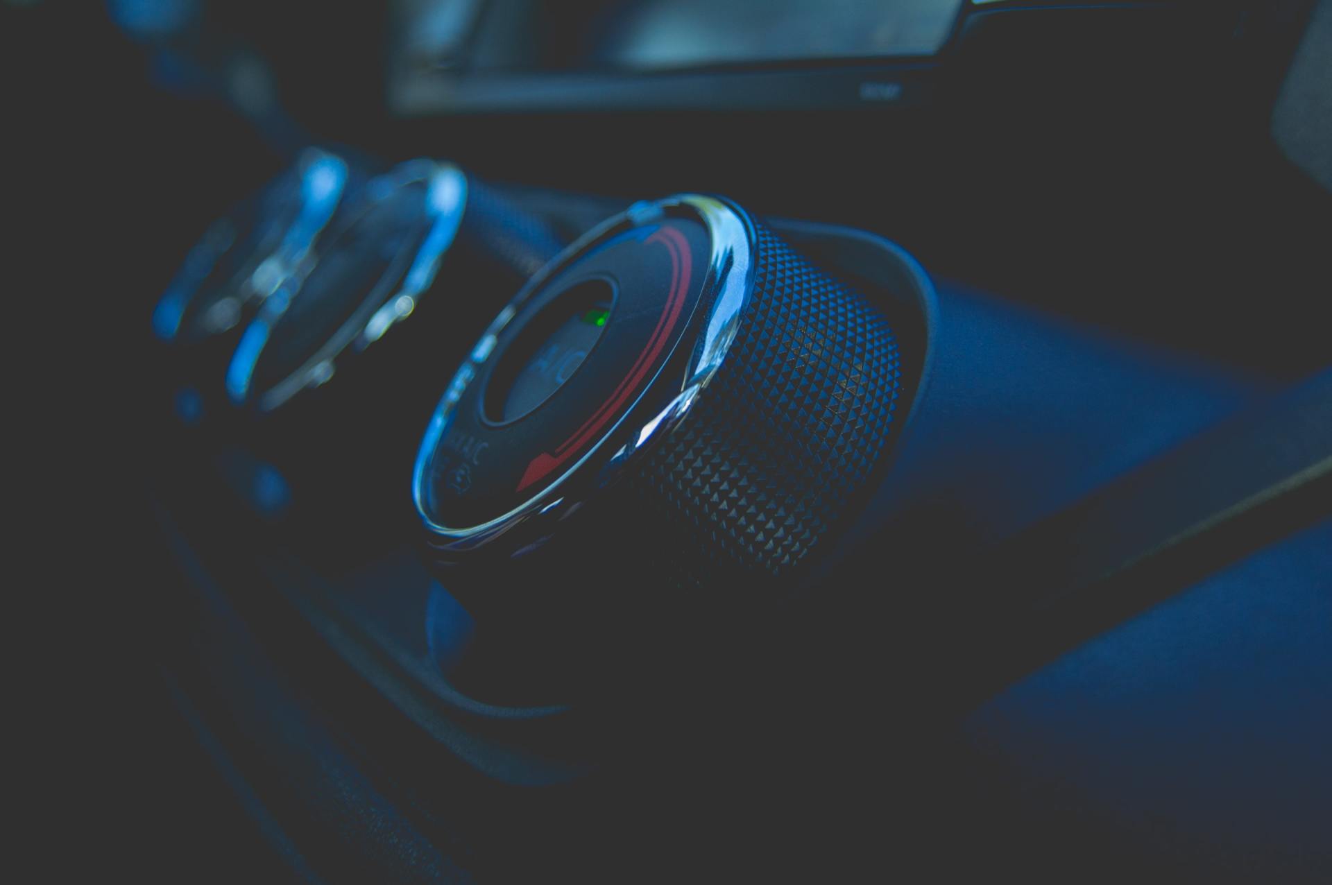 A close up of a car 's climate control knobs in a dark room.