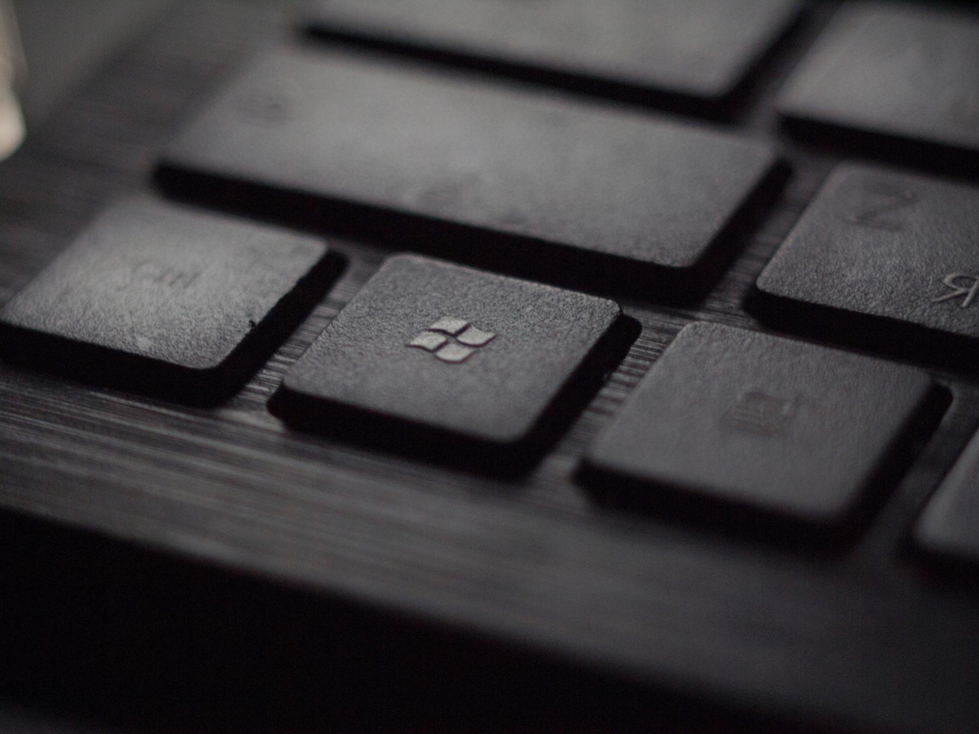 A close up of a black keyboard with the windows key in the middle
