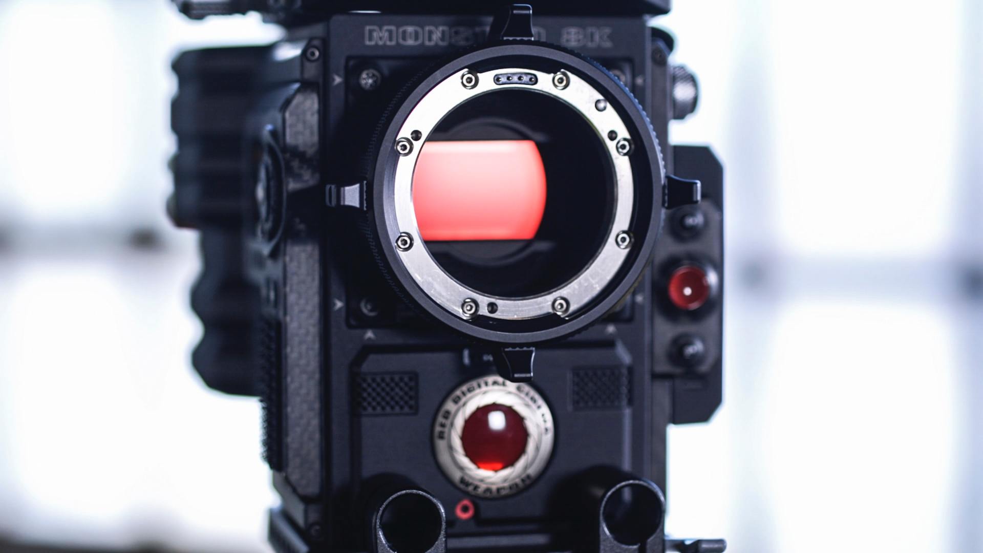 A close up of a camera with a red lens.
