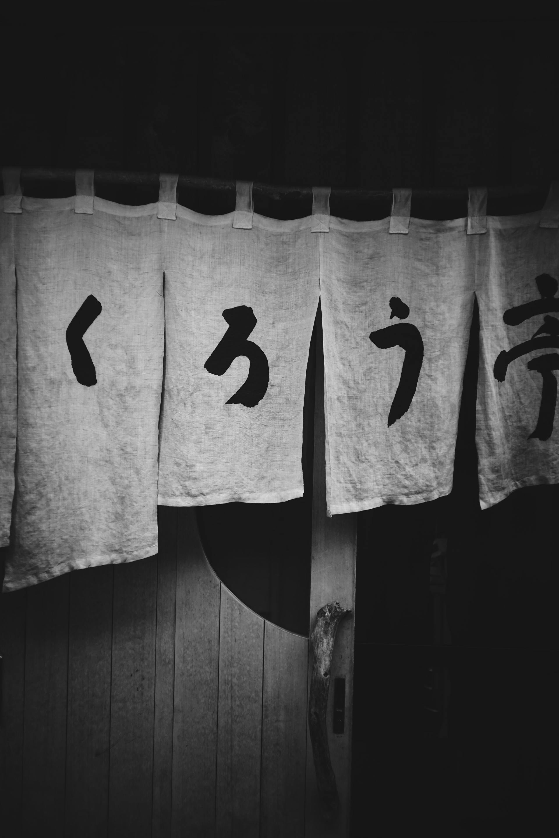 A black and white photo of a curtain with chinese writing on it