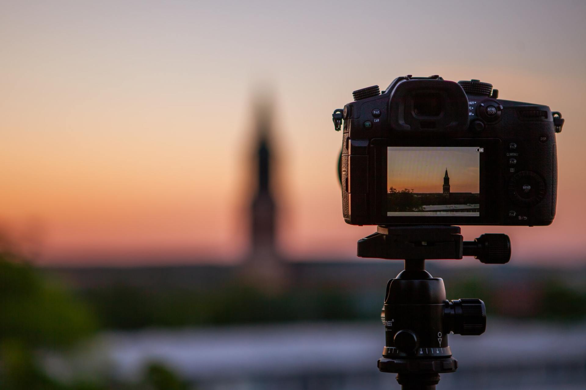 a camera is sitting on a tripod with a sunset in the background