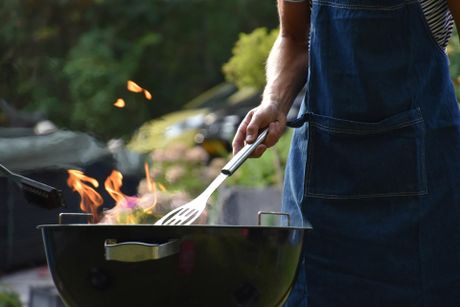 Person cooking on Charcoal BBQ