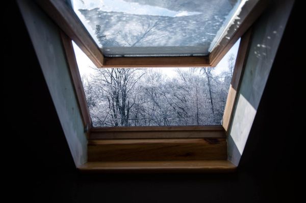 Skylight Window installed by ACE with a view of the snowy trees outside. Window is open.