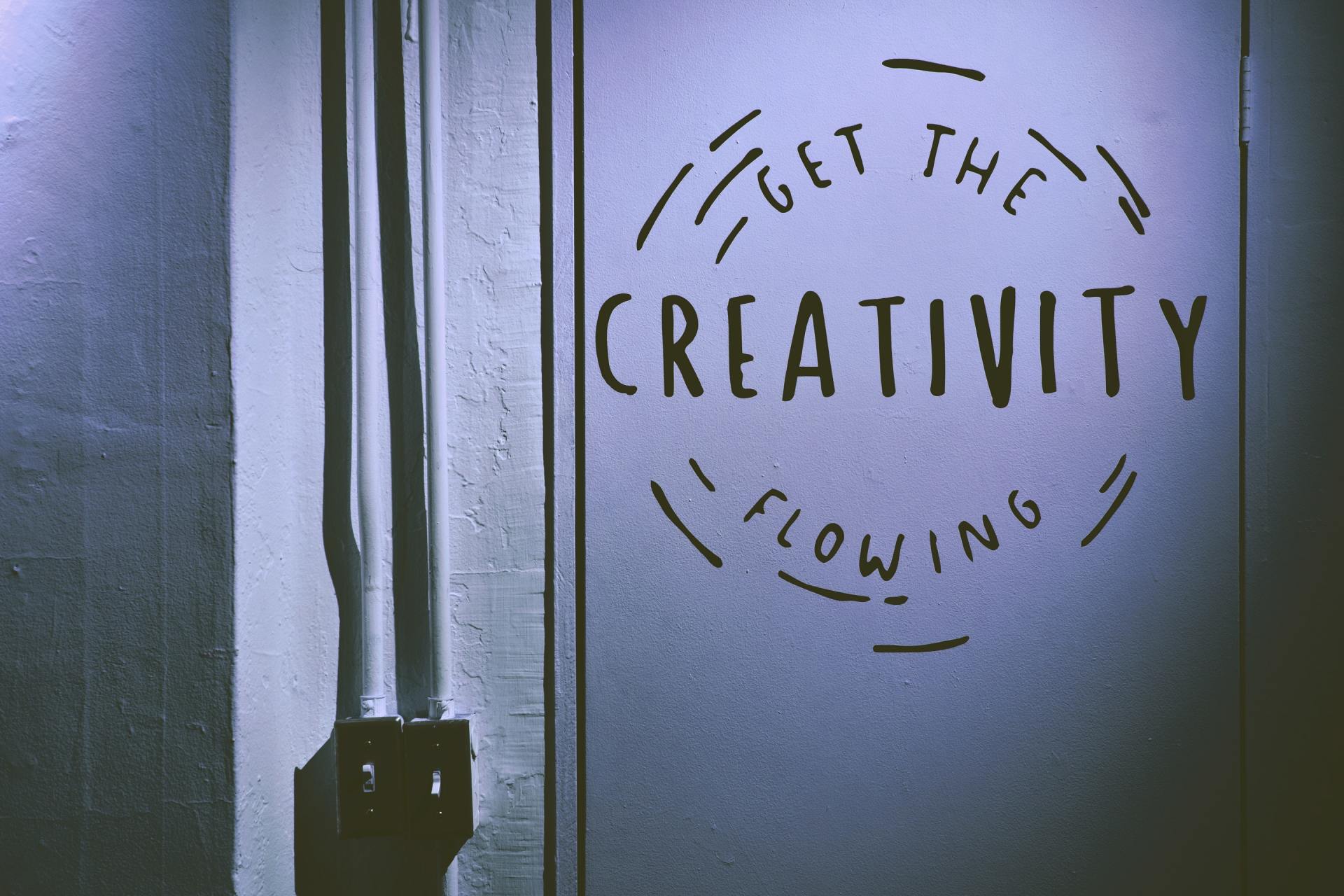 A sign on a wall that says get the creativity flowing