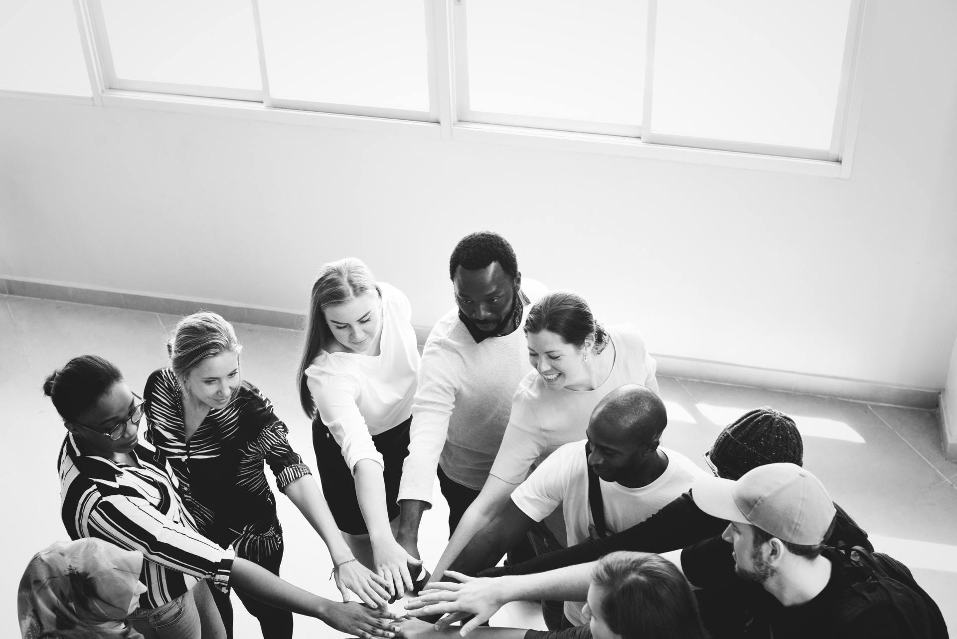A team of people in a circle with hands in the center. Join Optimal Home Care and become a part of a team that makes a difference.