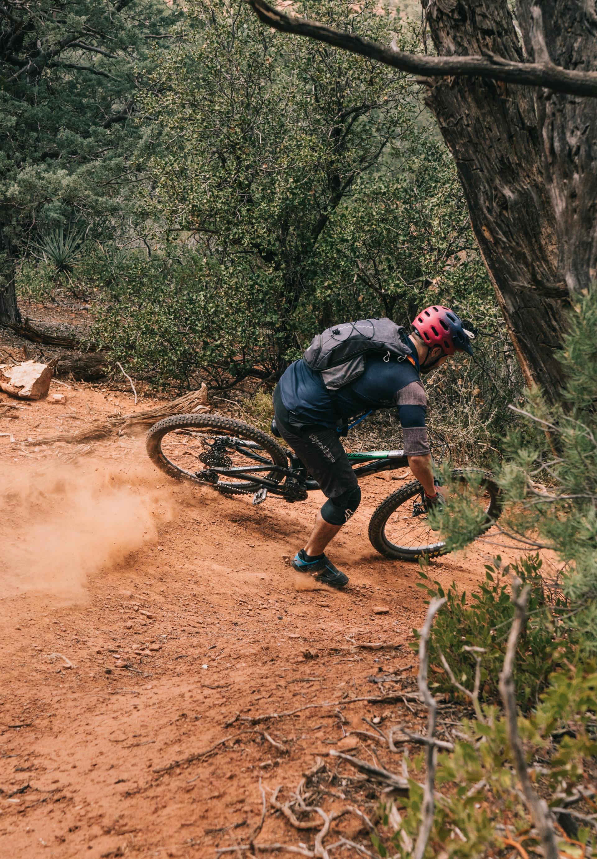 Un homme fait du VTT sur un sentier de terre.