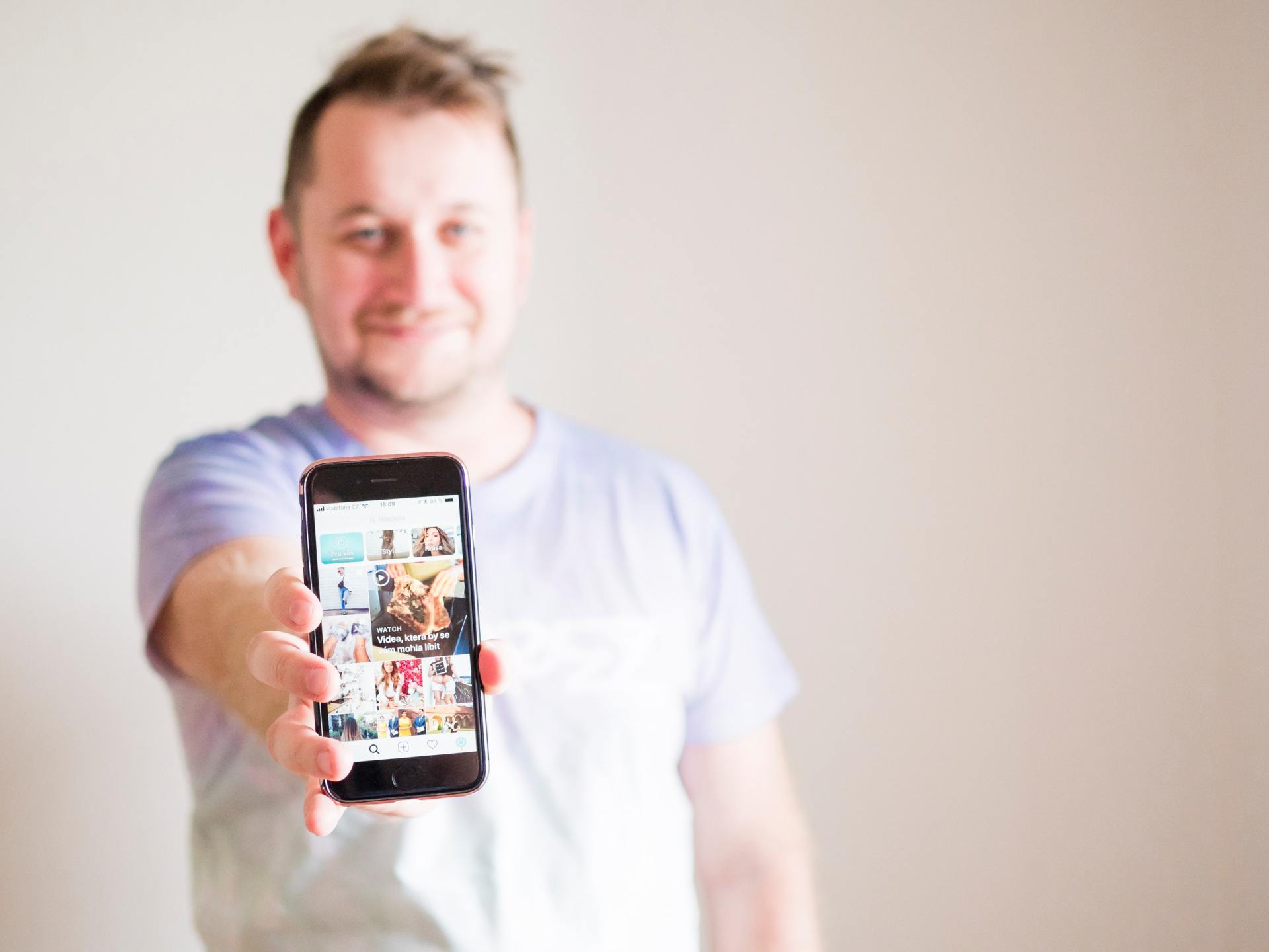 A man is holding a cell phone in his hand.