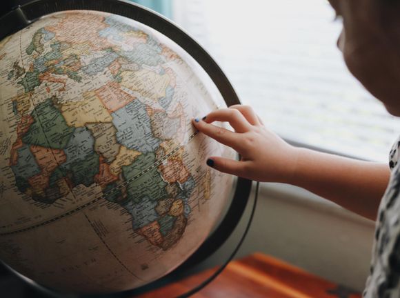 kid pointing at a place on the globe