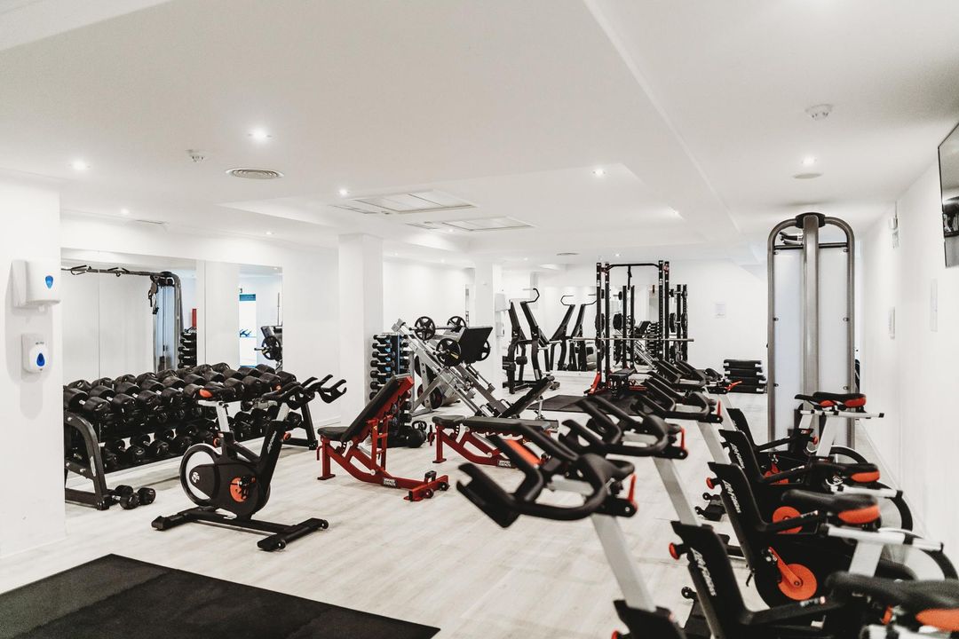 a gym filled with exercise bikes and dumbbells