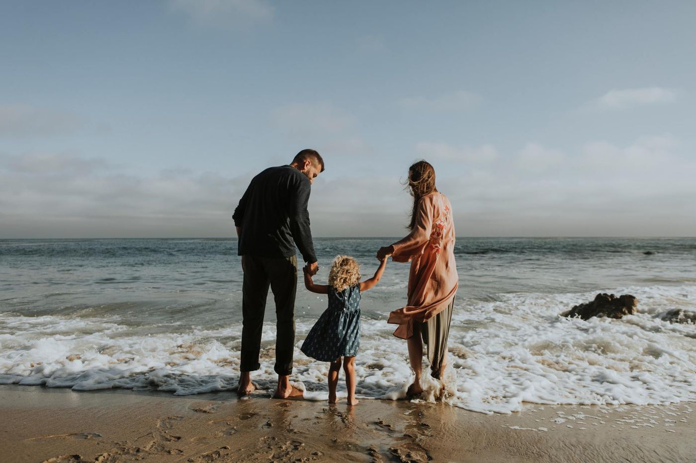 Man and women with child standing on the beach