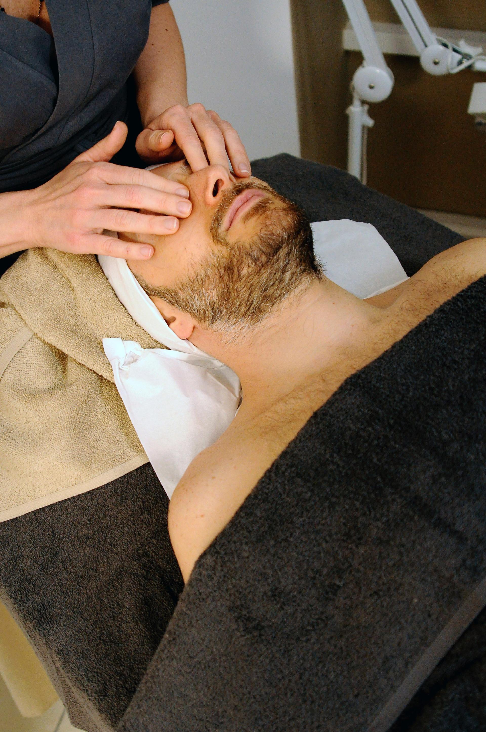 A man with a beard is getting a massage at a spa.