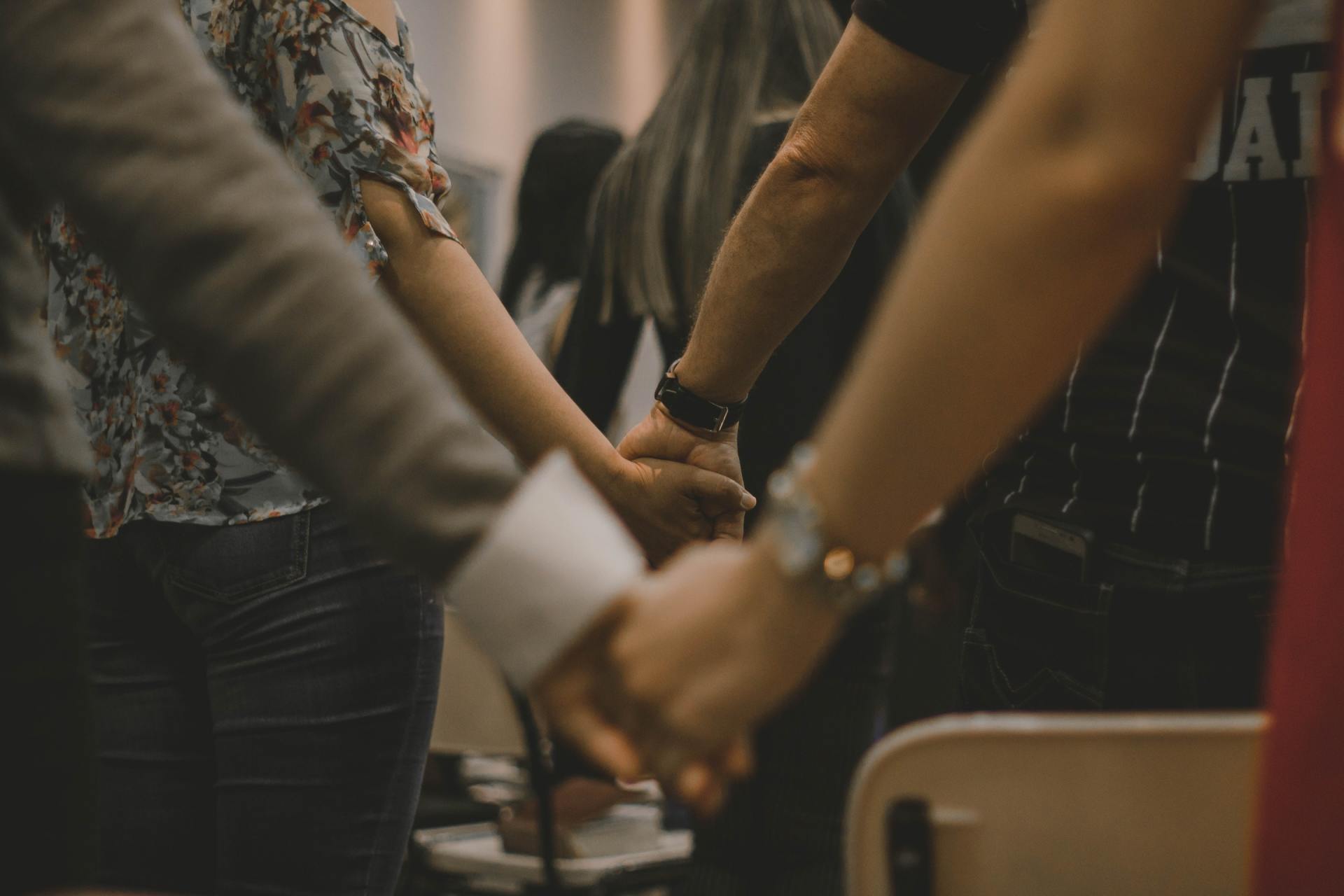 A group of people are holding hands in a circle.
