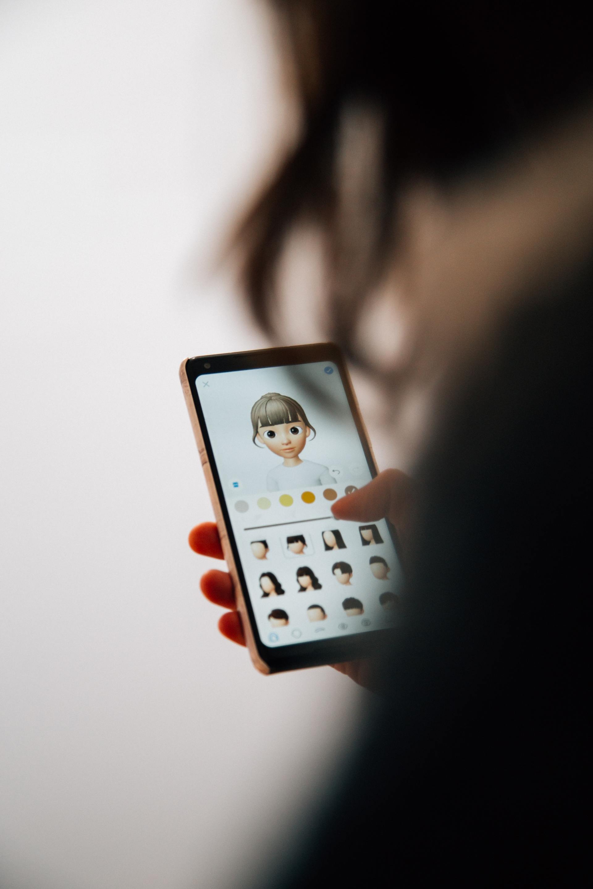 A person is holding a cell phone with a picture of a girl on the screen.
