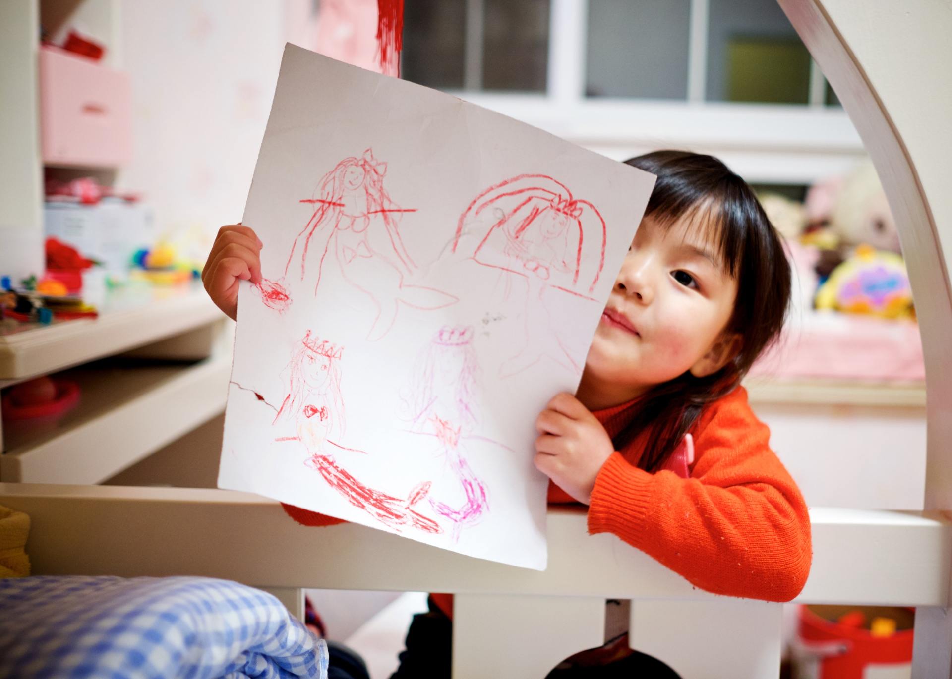Asian child showing her drawing