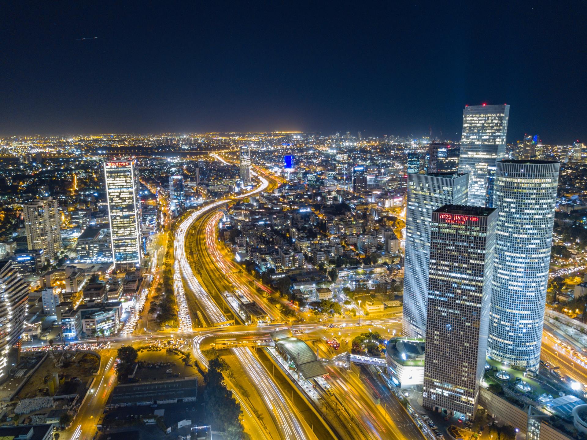 Aerial photo of Tel Aviv at night, showing skyscrapers, lights and blur of traffic