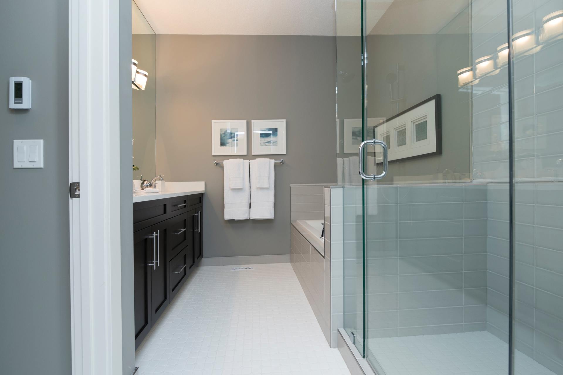 A bathroom with a walk in shower , sink , and mirror.