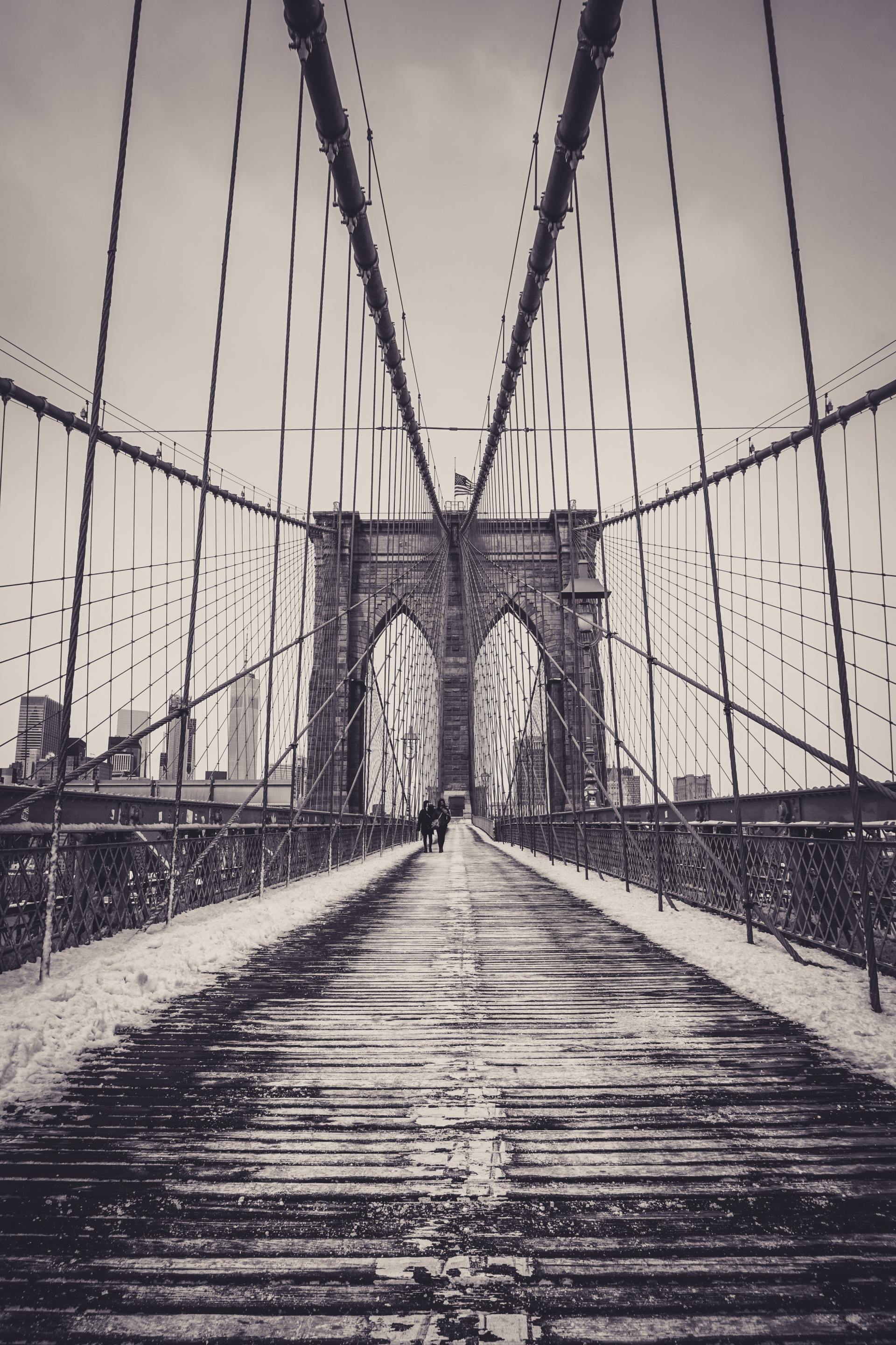 A black and white photo of a bridge in the snow