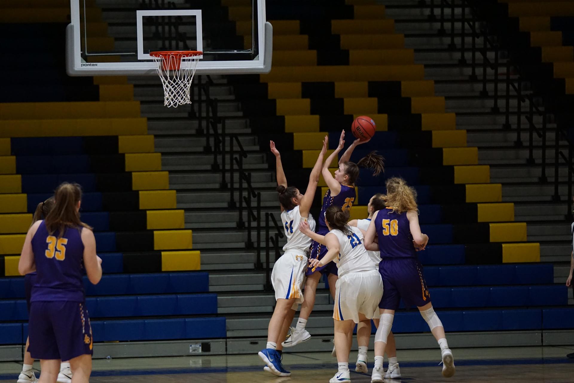 A group of women are playing basketball in a gym.