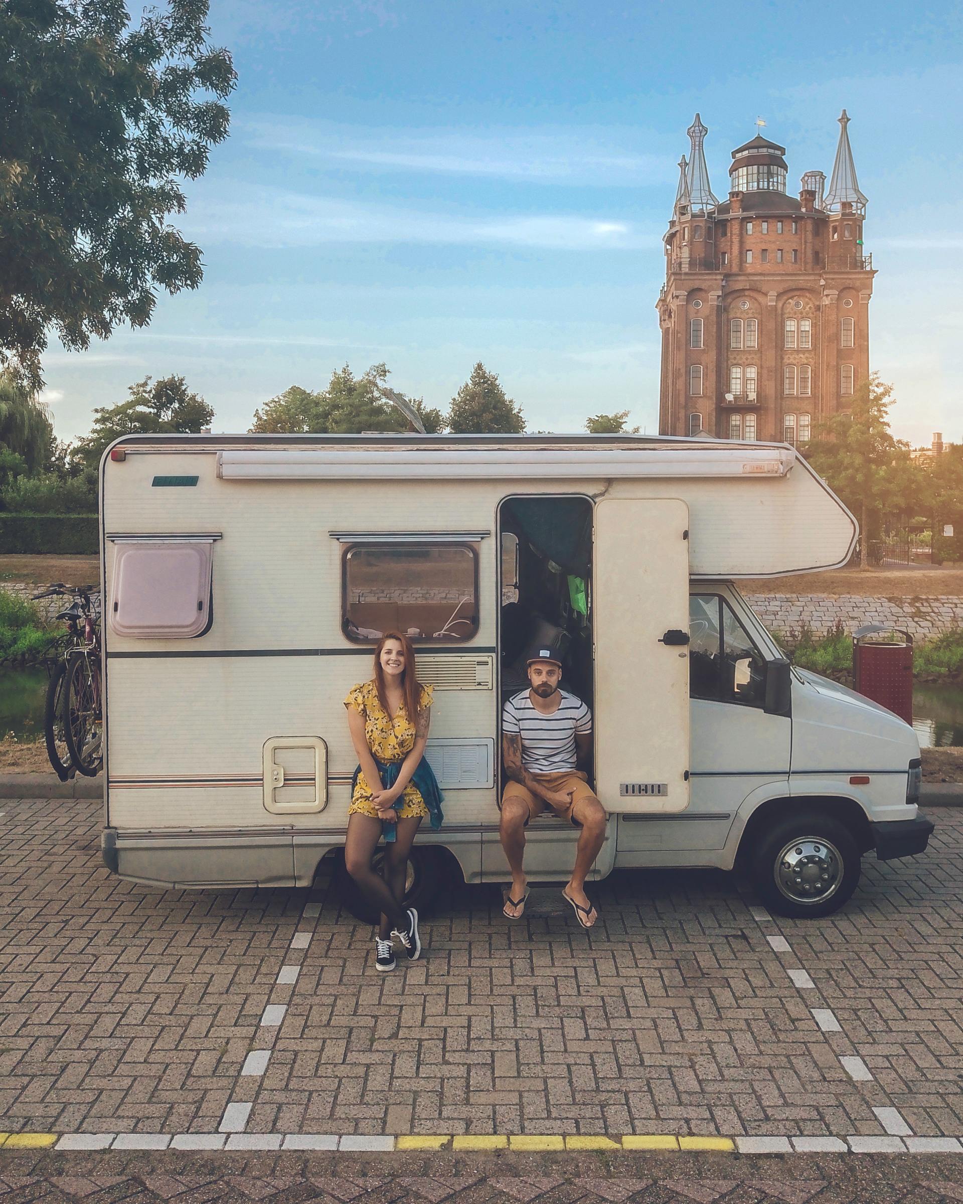 A young couple sitting in front of their RV