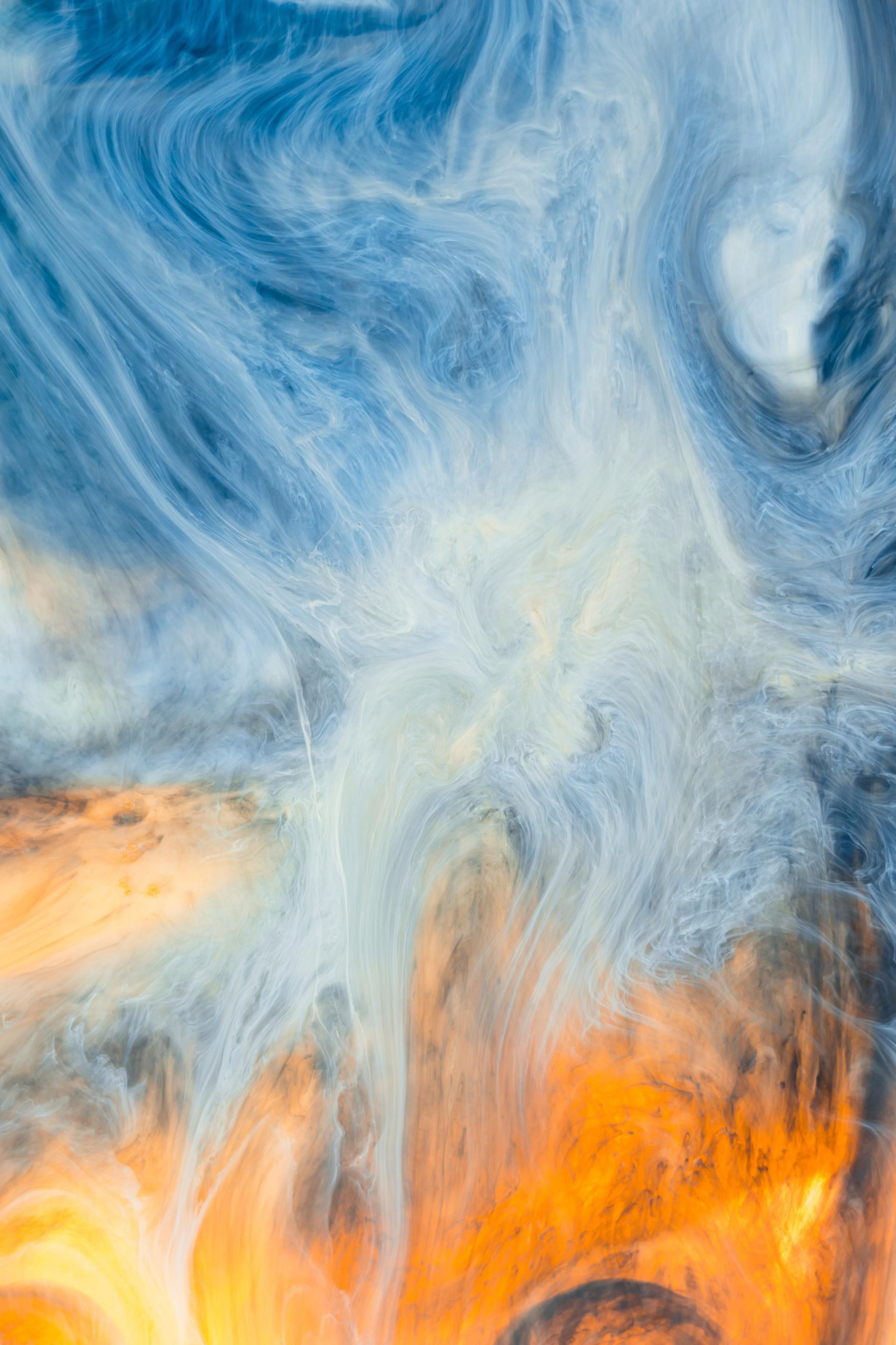 A close up of a blue and orange painting with smoke coming out of it.