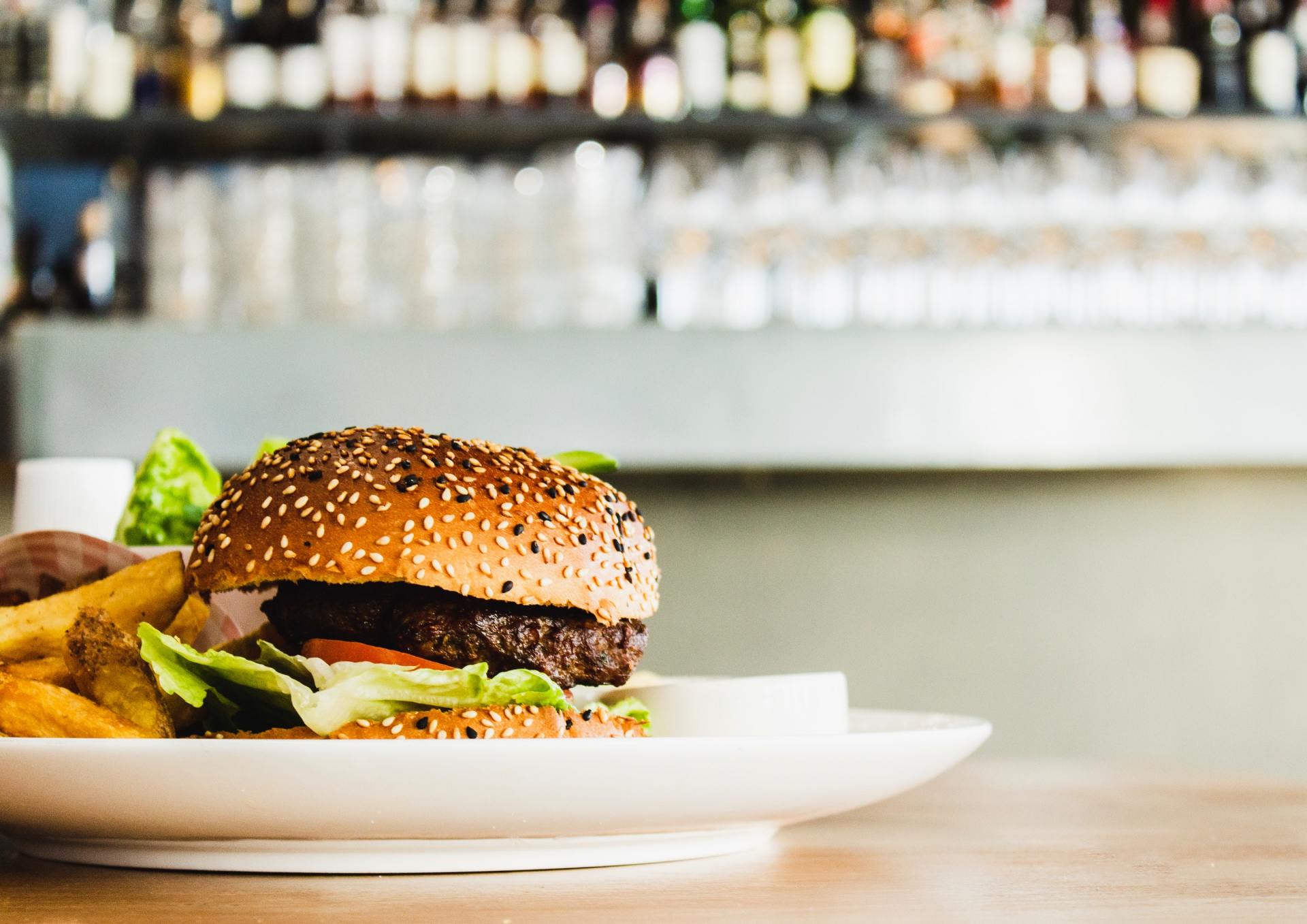 A hamburger and french fries on a white plate on a table.