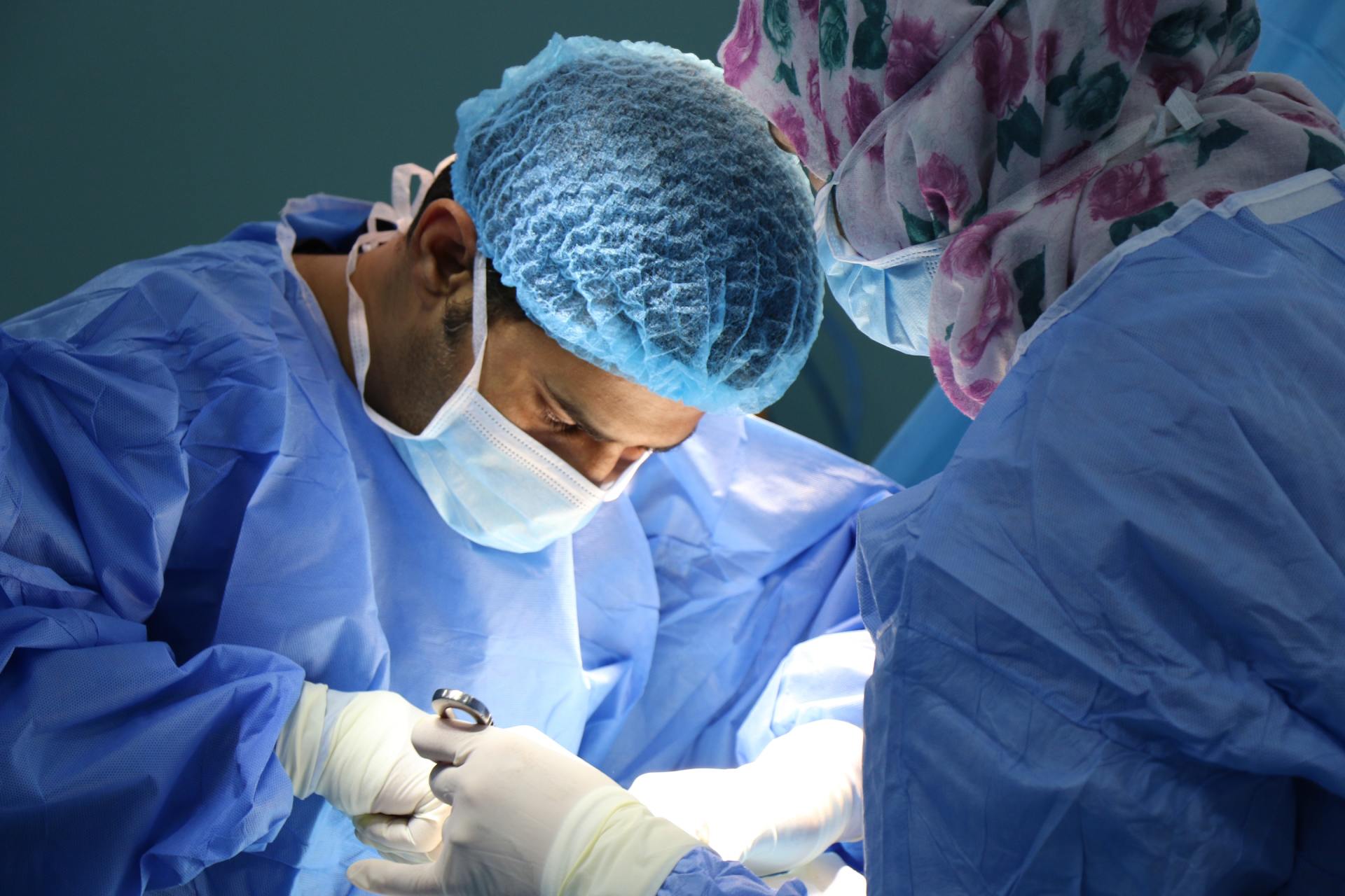 A surgeon is operating on a patient in an operating room.
